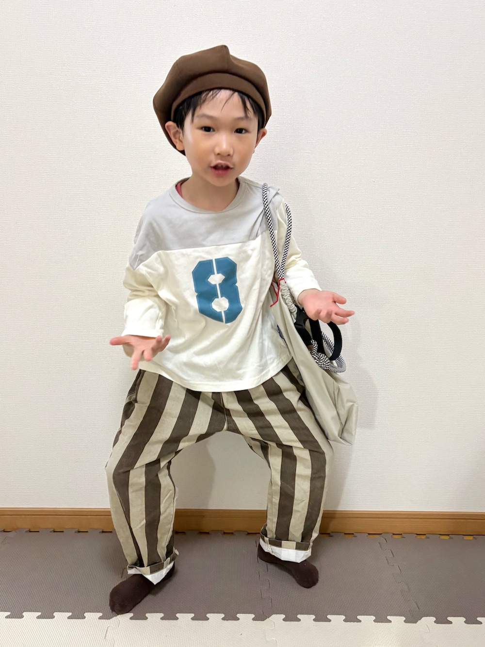 グレー系のTシャツ/カットソー、ブラウン系のその他パンツ、ベージュ系のトートバッグを着用したキッズの春コーディネートの3枚目の写真