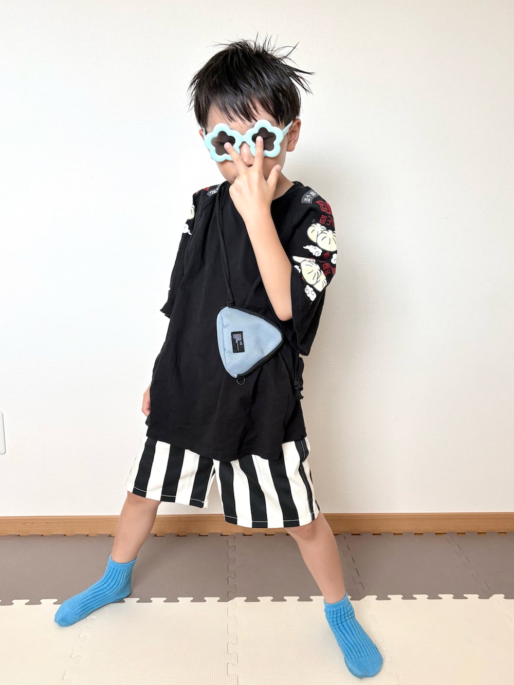 ブラック系のTシャツ/カットソー、ホワイト系のパンツ、ブルー系のサングラスを着用したキッズの夏コーディネートの5枚目の写真
