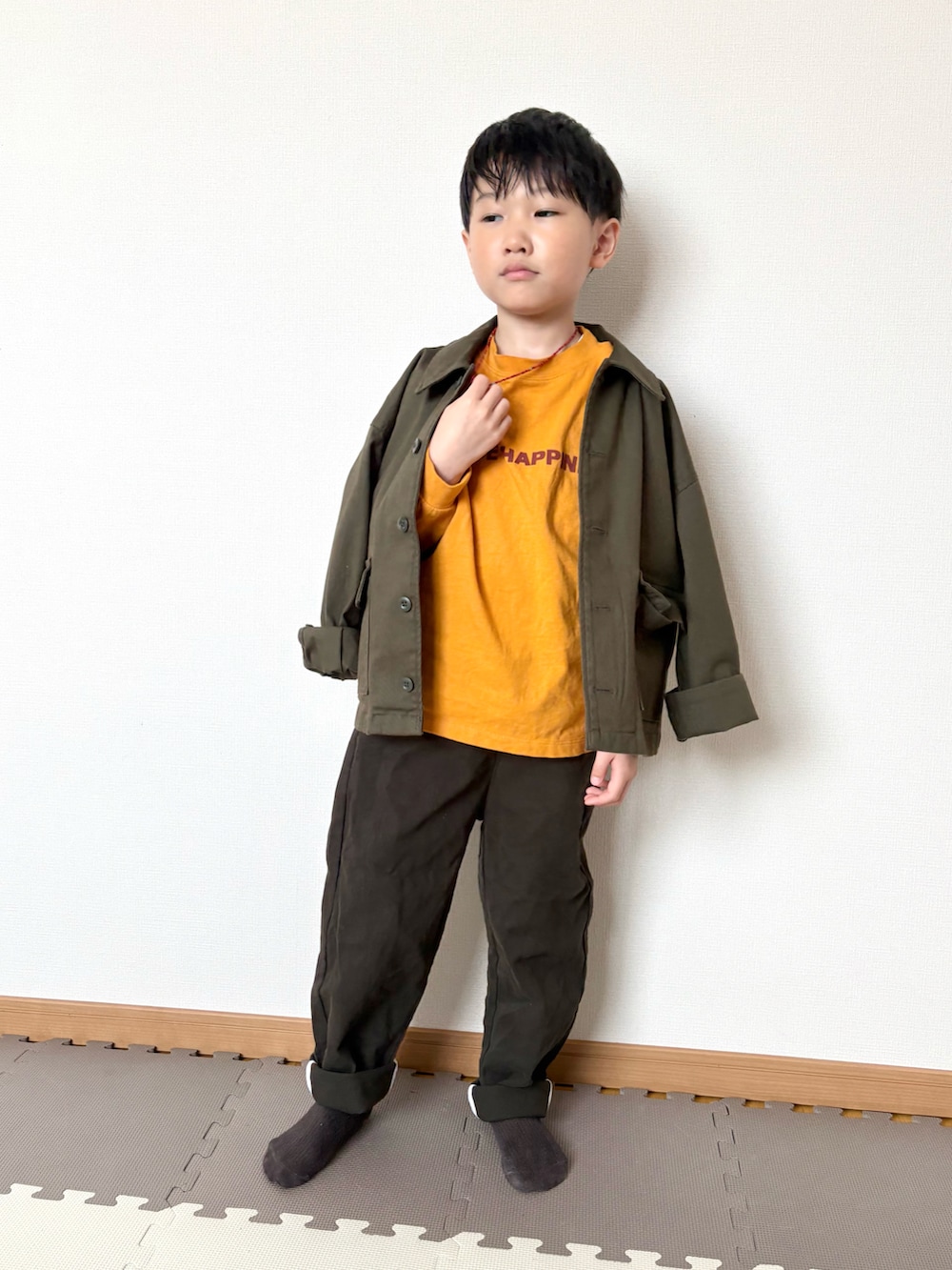 イエロー系のTシャツ/カットソー、グリーン系のジャケット/アウター、ブラウン系のチノパンツを着用したキッズの春コーディネートの5枚目の写真