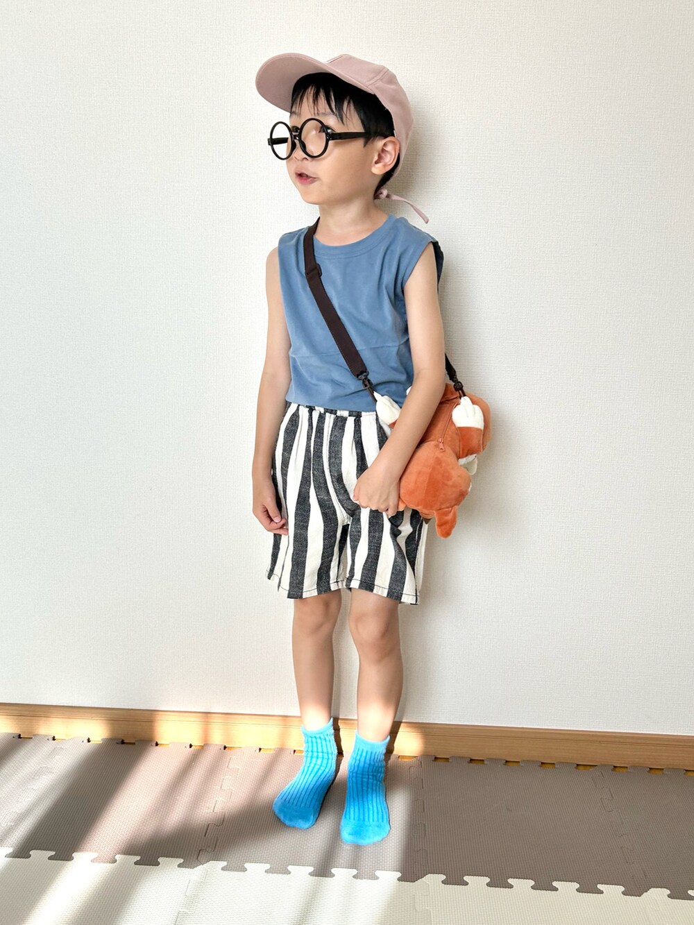 ブルー系のタンクトップ、ホワイト系のパンツ、ブラウン系のショルダーバッグを着用したキッズの夏コーディネートの5枚目の写真