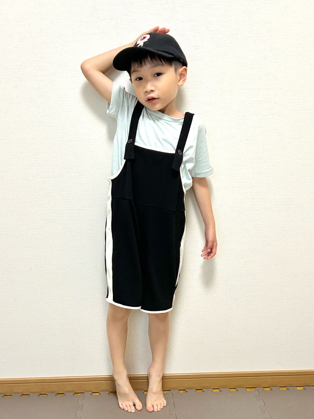 グリーン系のTシャツ/カットソー、ブラック系のサロペット/オーバーオール、ホワイト系のキャップを着用したキッズの夏コーディネートの3枚目の写真