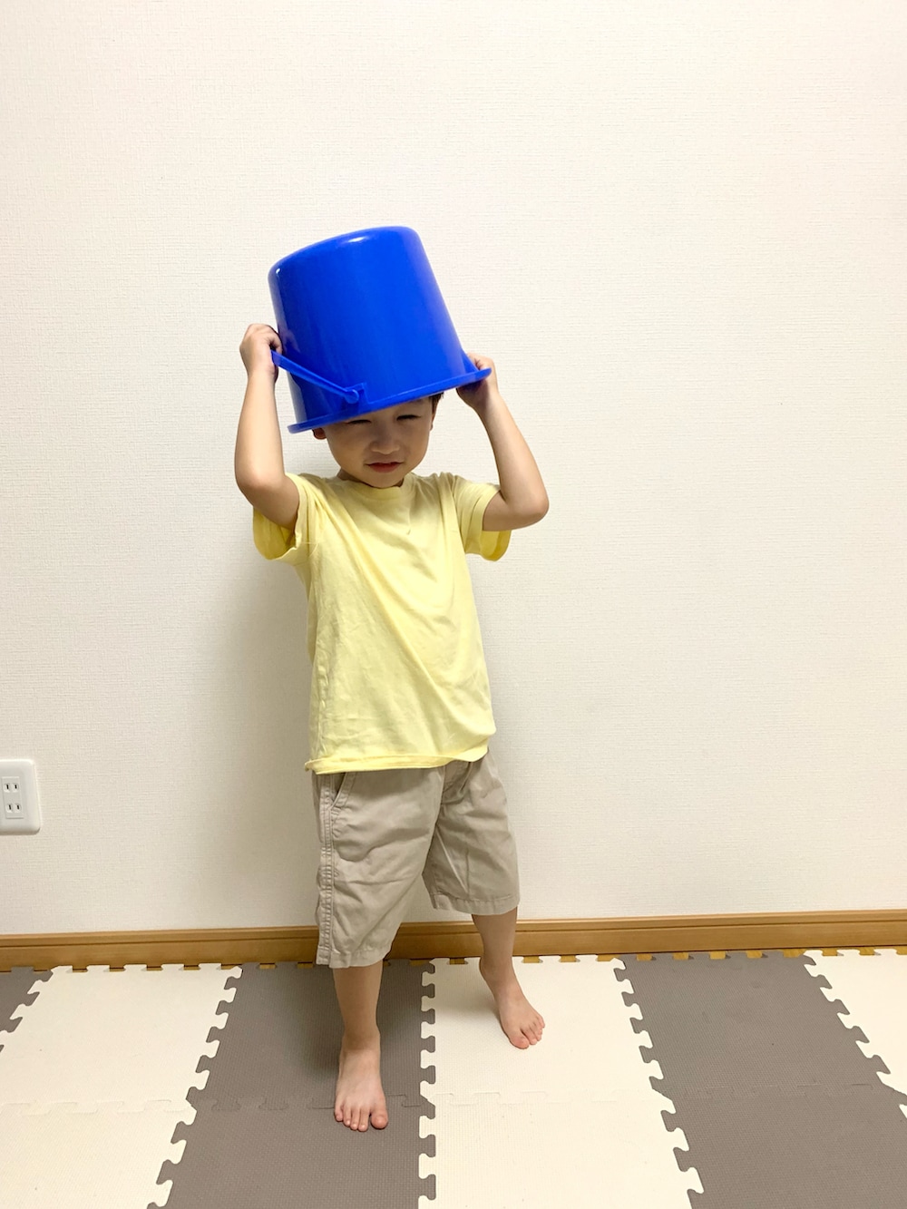 イエロー系のTシャツ/カットソー、ベージュ系のチノパンツ、ブルー系のランドリーグッズを着用したキッズの秋コーディネートの4枚目の写真