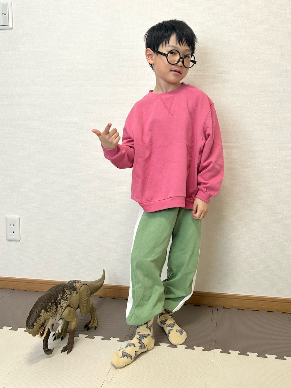 ピンク系のスウェット、グリーン系のスウェットパンツ、ベージュ系のソックス/靴下を着用したキッズの冬コーディネートの3枚目の写真