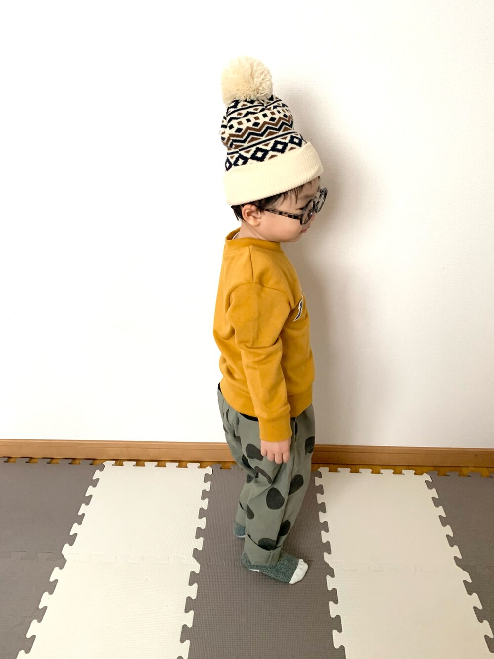 イエロー系のスウェット、グリーン系のその他パンツ、ホワイト系のニットキャップ/ビーニーを着用したキッズの秋コーディネートの2枚目の写真
