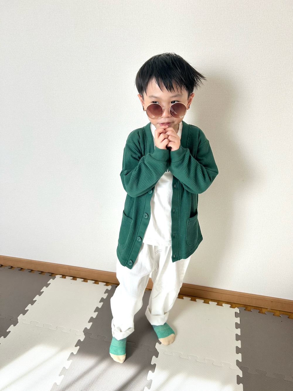 ホワイト系のデニムパンツ、ホワイト系のTシャツ/カットソー、グリーン系のカーディガン/ボレロを着用したキッズの春コーディネートの2枚目の写真