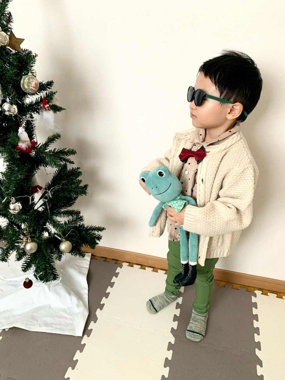 グリーン系のデニムパンツ、ベージュ系のカーディガン/ボレロ、ベージュ系のシャツ/ブラウスを着用したキッズの冬コーディネートの3枚目の写真