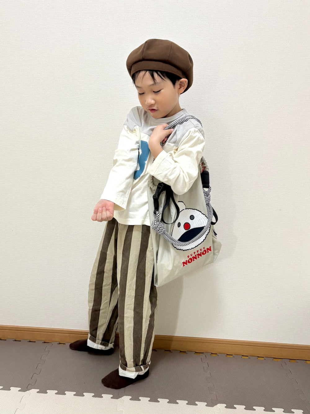 グレー系のTシャツ/カットソー、ブラウン系のその他パンツ、ベージュ系のトートバッグを着用したキッズの春コーディネートの2枚目の写真
