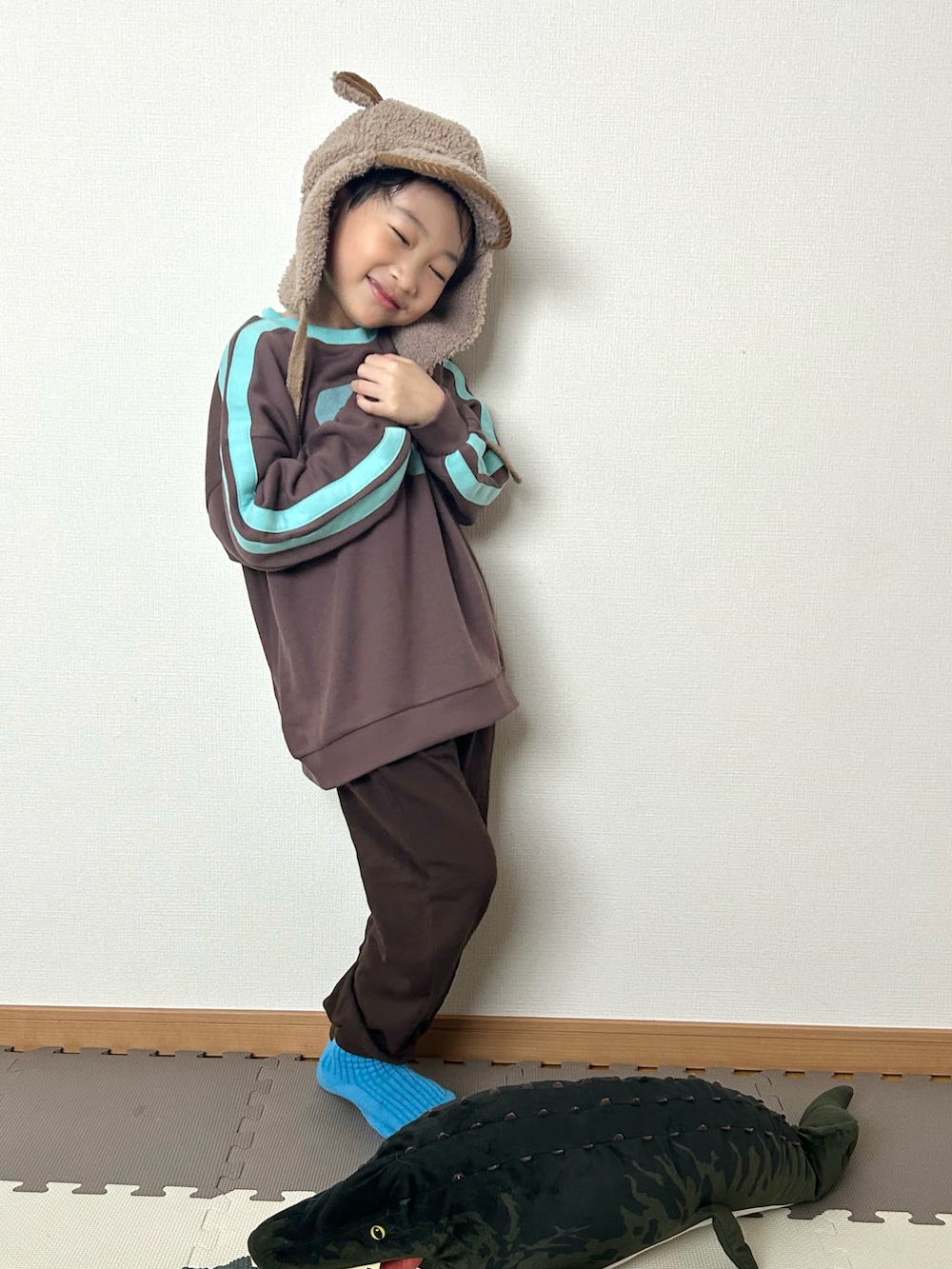 ブラウン系のスウェット、ブラウン系のスウェットパンツ、ブラウン系の帽子を着用したキッズの冬コーディネートの3枚目の写真