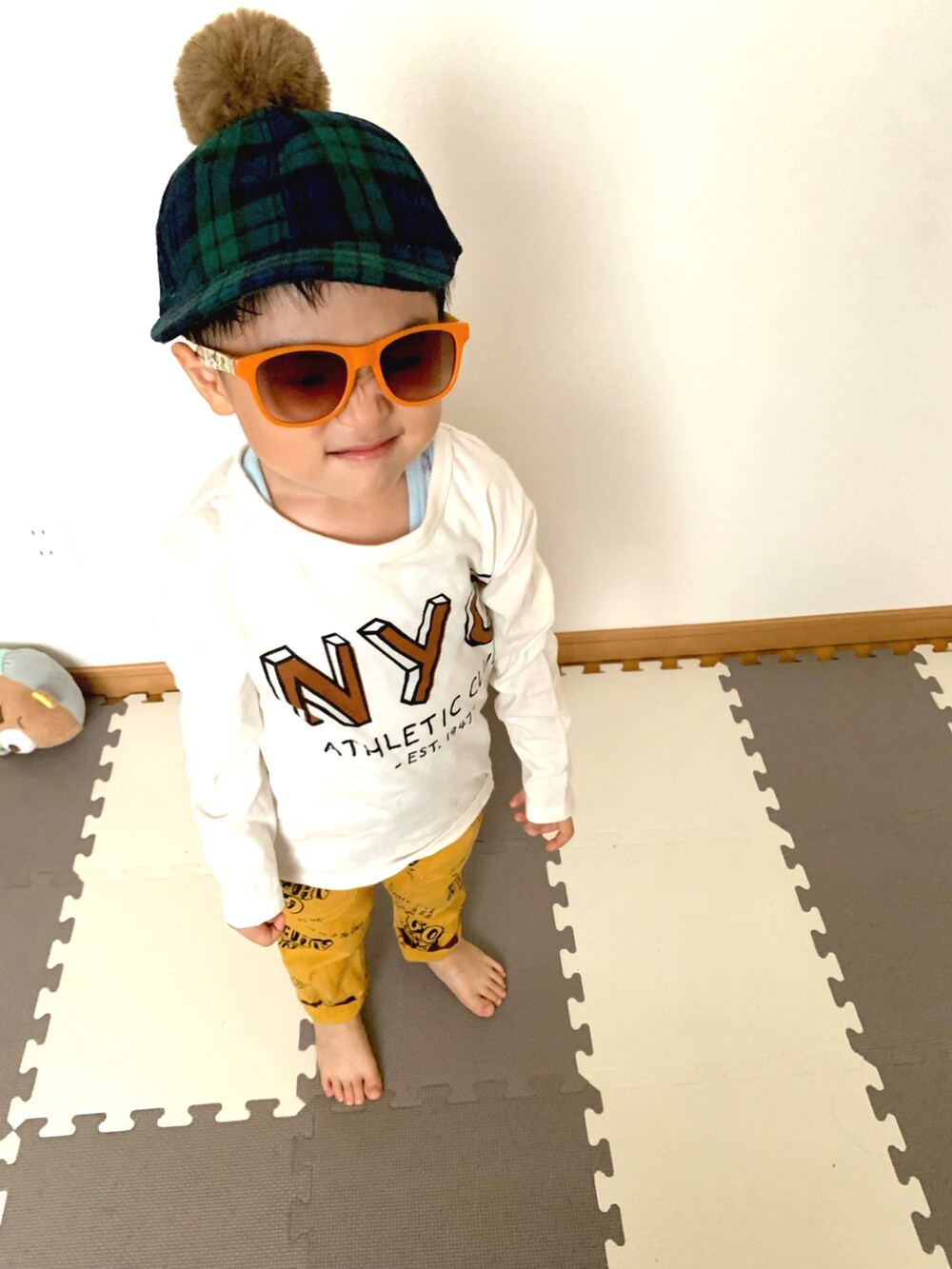 ホワイト系のTシャツ/カットソー、イエロー系のデニムパンツ、グリーン系のキャップを着用したキッズの秋コーディネートの2枚目の写真