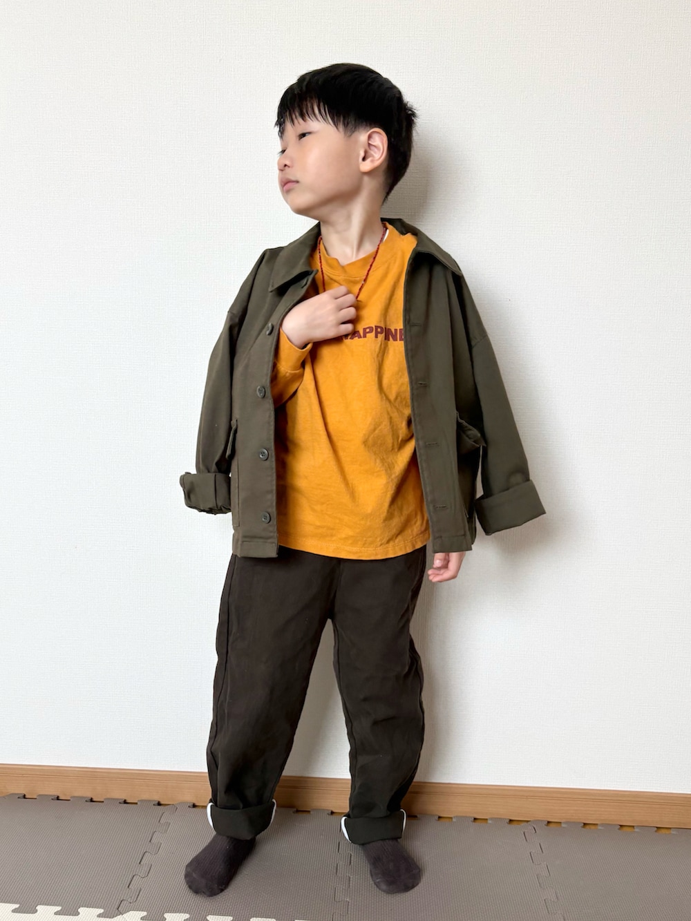 イエロー系のTシャツ/カットソー、グリーン系のジャケット/アウター、ブラウン系のチノパンツを着用したキッズの春コーディネートの2枚目の写真