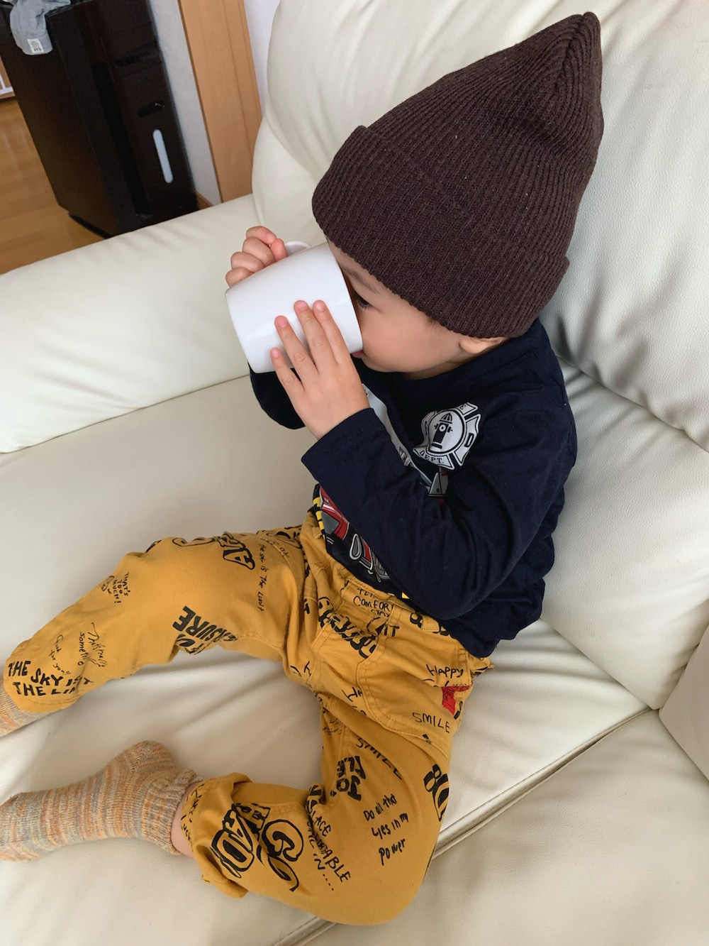 ブルー系のTシャツ/カットソー、イエロー系のチノパンツ、ブラウン系のニットキャップ/ビーニーを着用したキッズの秋コーディネートの4枚目の写真