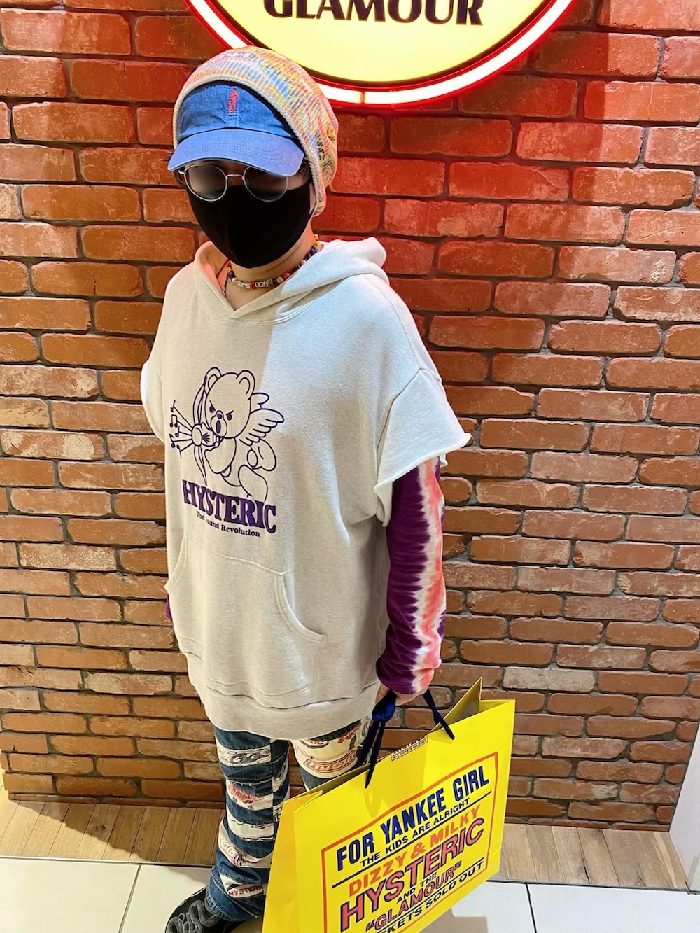 グレー系のパーカー、パープル系のTシャツ/カットソー、ブルー系のデニムパンツを着用したメンズの春コーディネートの2枚目の写真