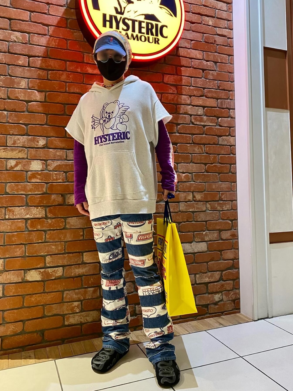 グレー系のパーカー、パープル系のTシャツ/カットソー、ブルー系のデニムパンツを着用したメンズの春コーディネートの3枚目の写真