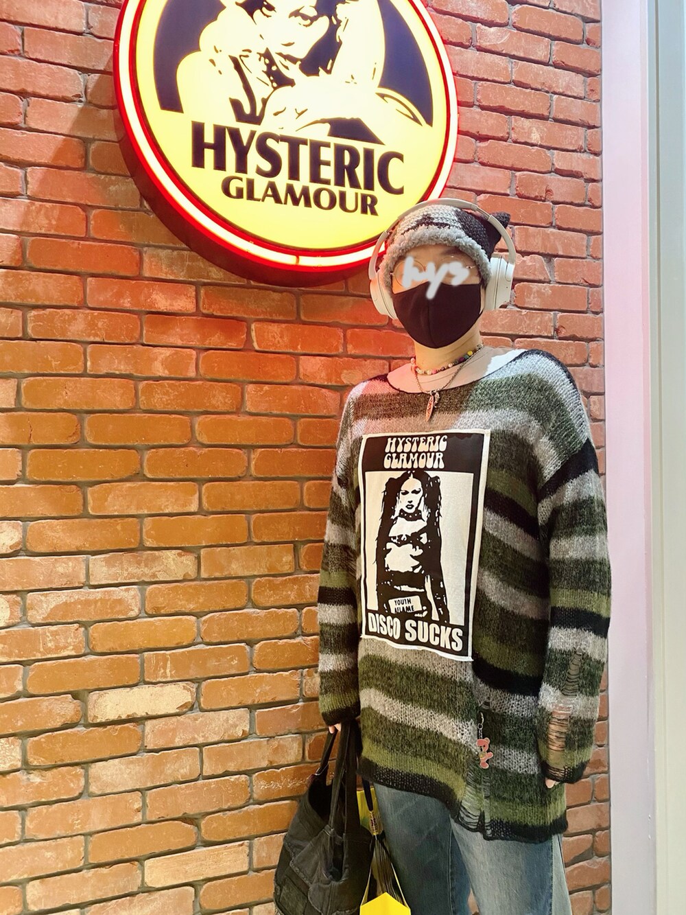 グリーン系のニット/セーター、ブルー系のデニムパンツ、ブラック系のショルダーバッグを着用したメンズの秋コーディネートの3枚目の写真