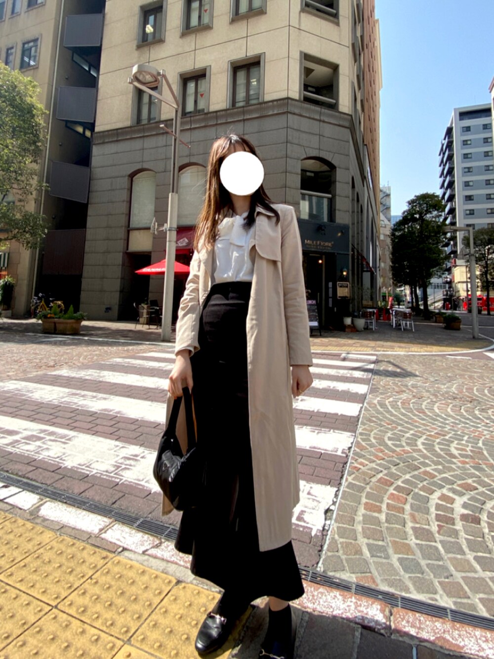 ベージュ系のトレンチコート、ブラック系のショルダーバッグ、ブラック系のローファーを着用したレディースの春コーディネートの3枚目の写真