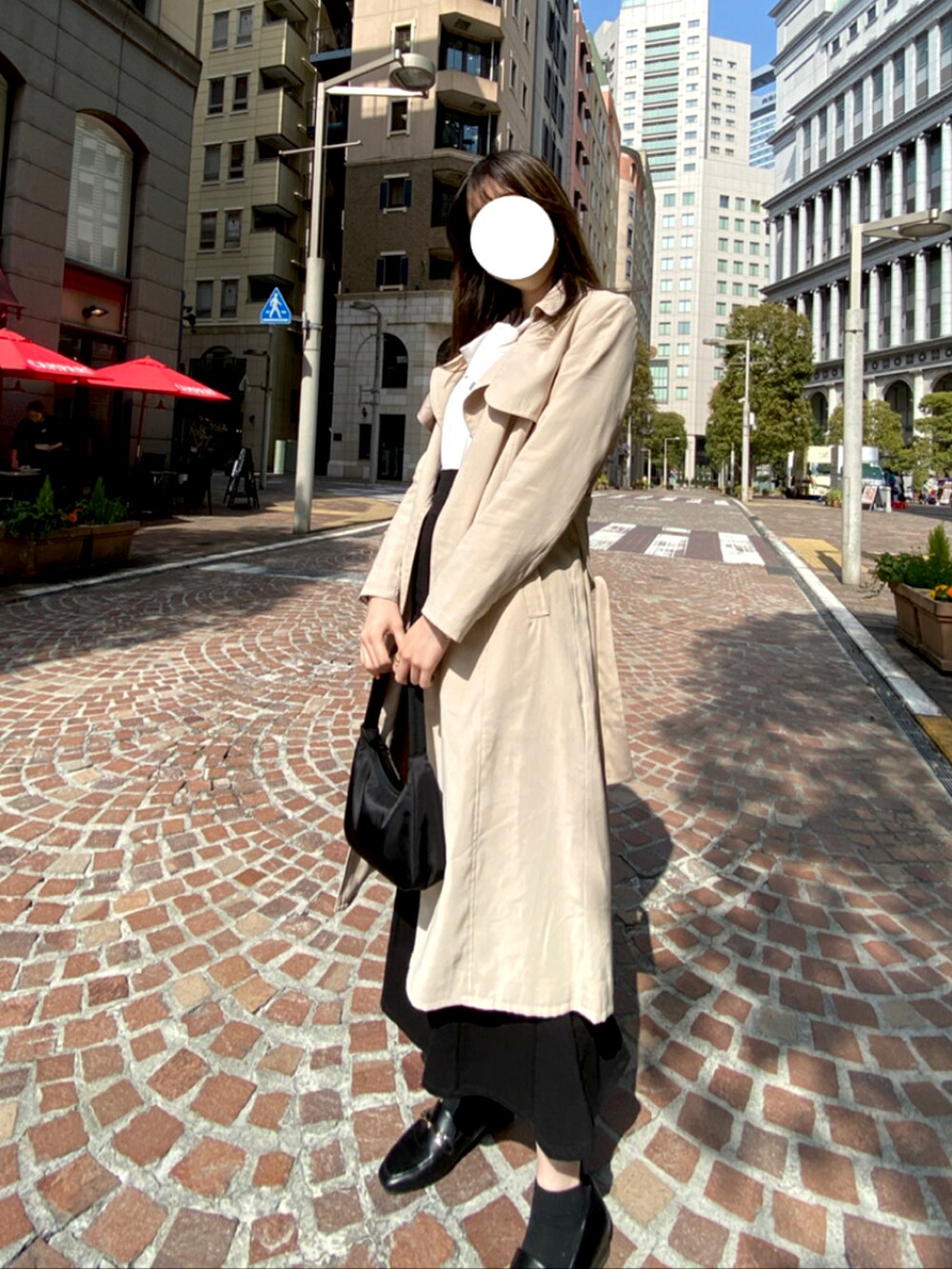 ベージュ系のトレンチコート、ブラック系のショルダーバッグ、ブラック系のローファーを着用したレディースの春コーディネートの2枚目の写真