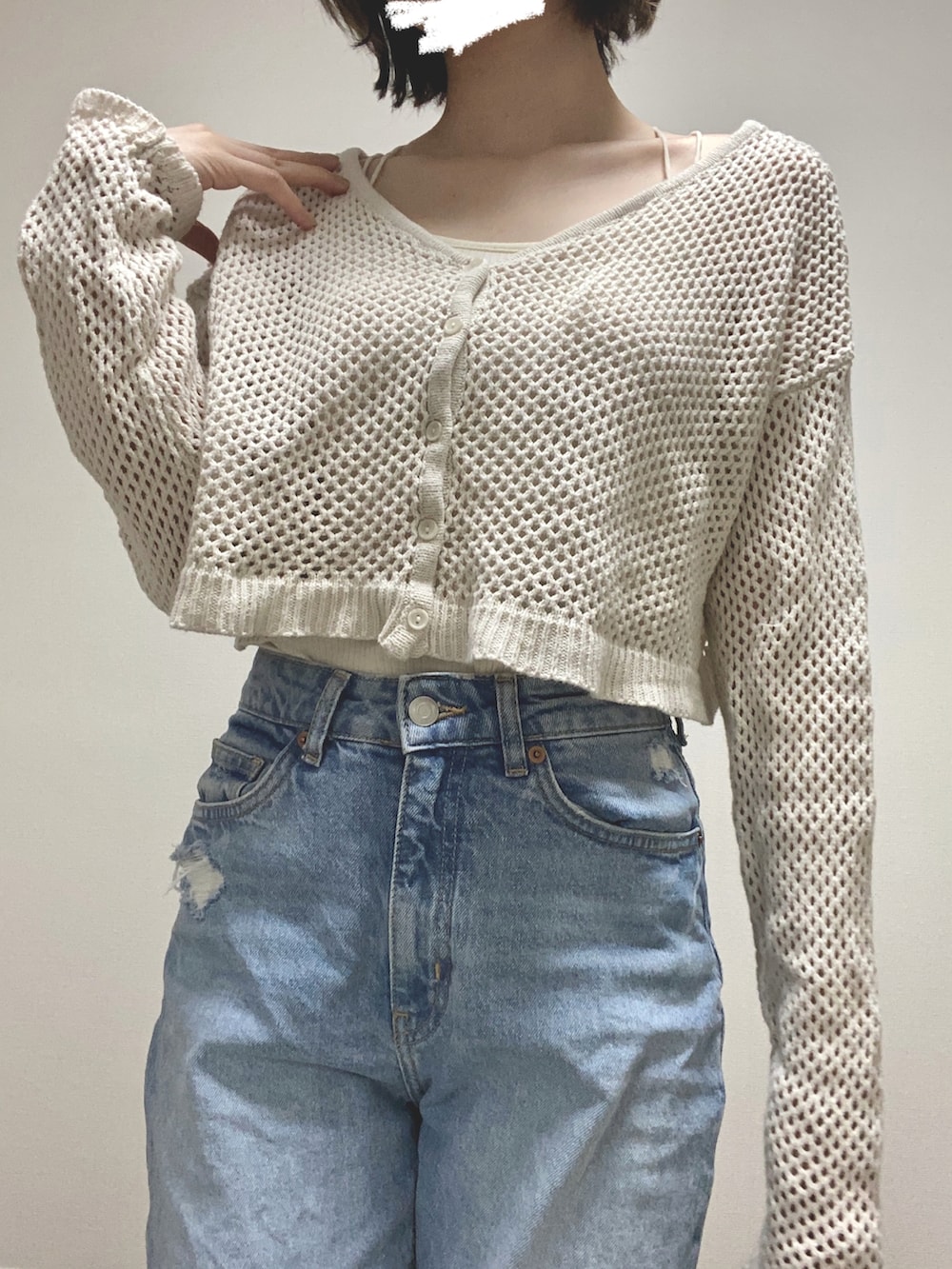 ブルー系のデニムパンツ、ベージュ系のニット/セーター、ホワイト系のキャミソールを着用したレディースの夏コーディネートの2枚目の写真