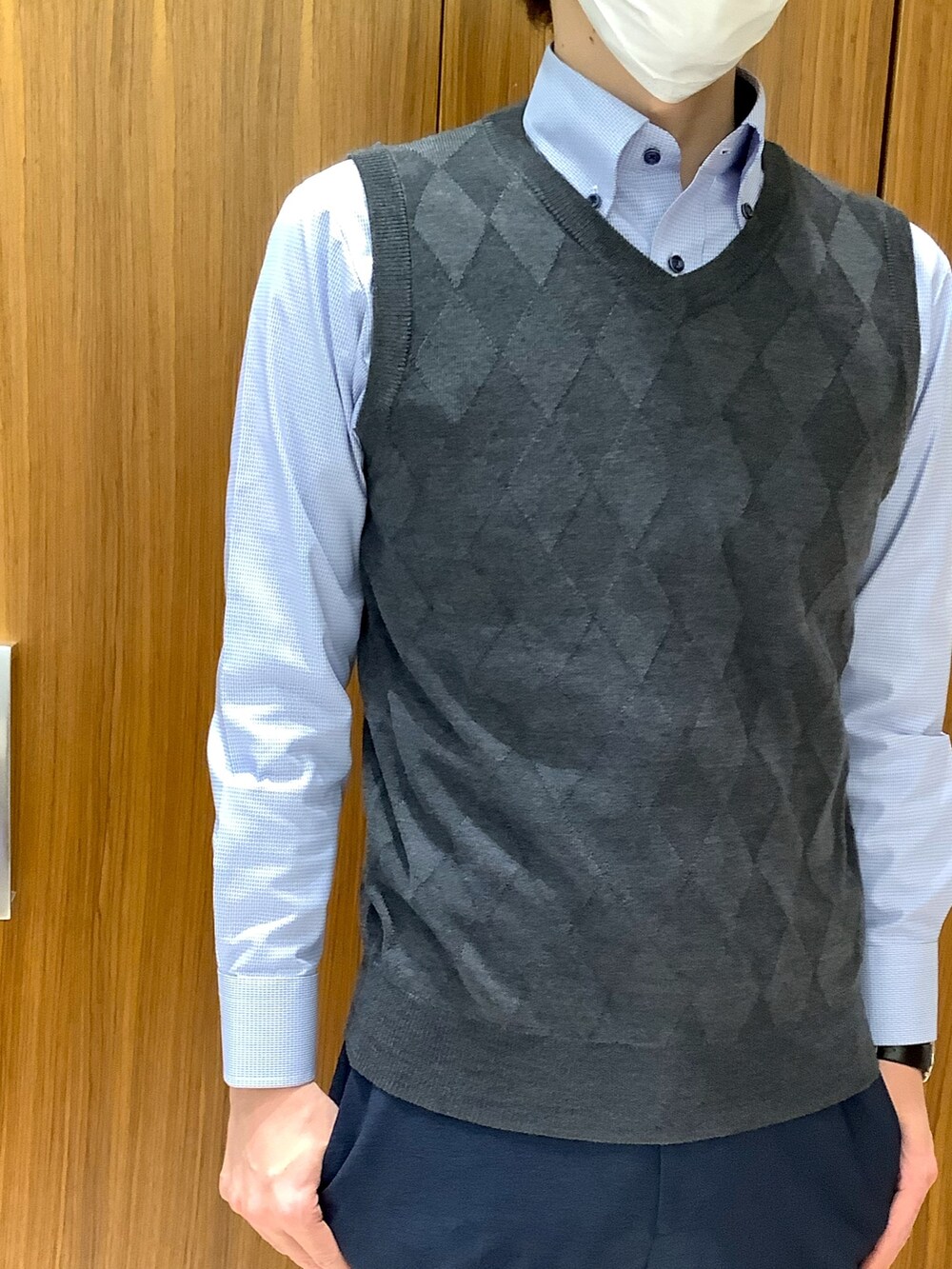 グレー系のベスト、ブルー系のビジネスシャツを着用したメンズの冬コーディネートの2枚目の写真