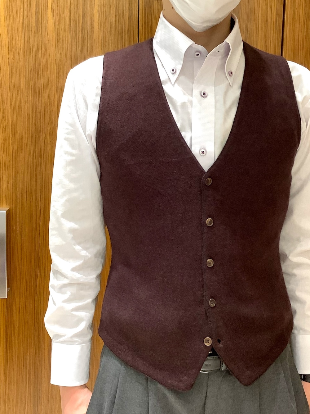 ブラウン系のベスト、パープル系のビジネスシャツを着用したメンズの冬コーディネートの2枚目の写真