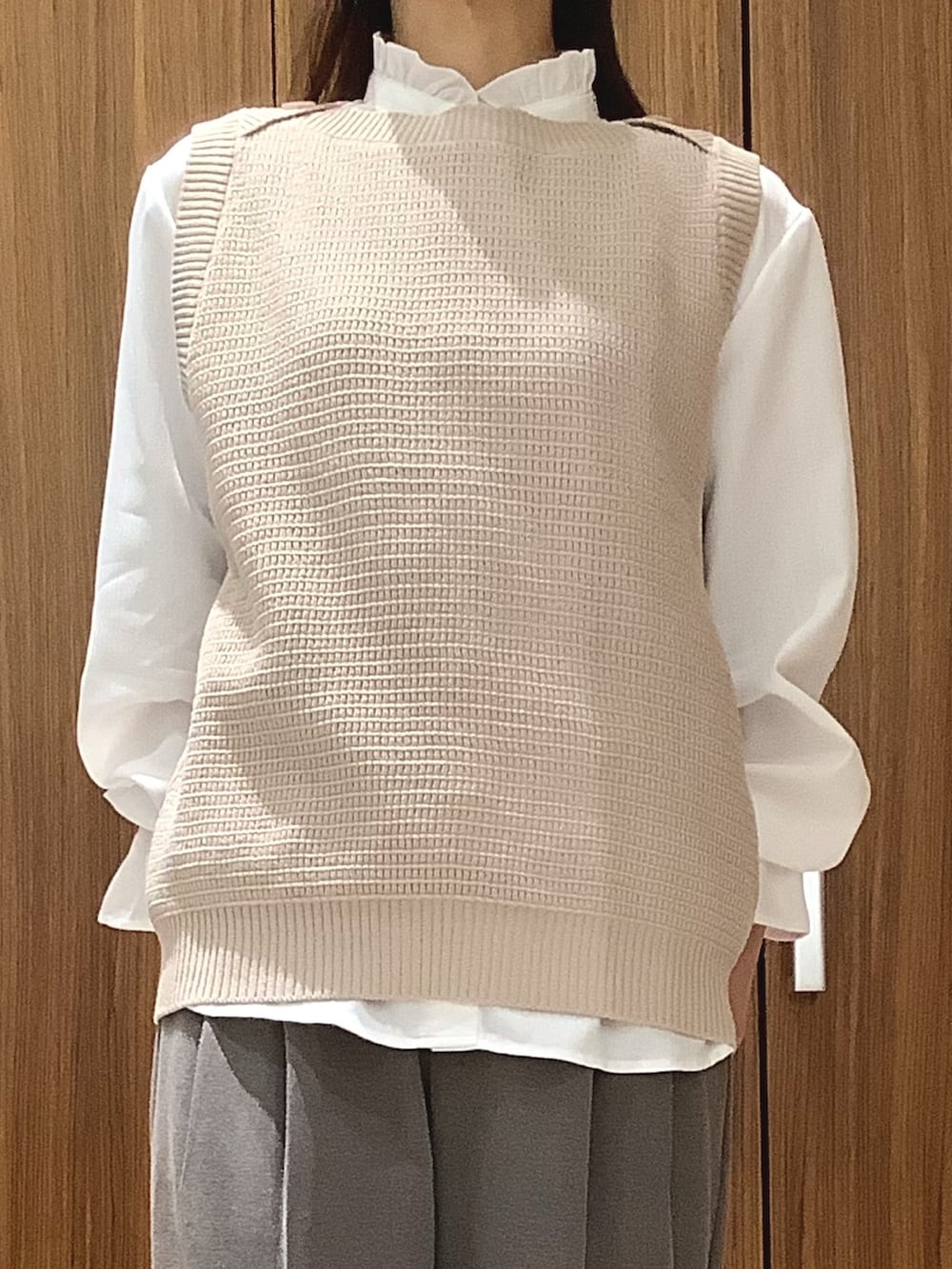 ベージュ系のベストを着用したレディースの春コーディネートの2枚目の写真