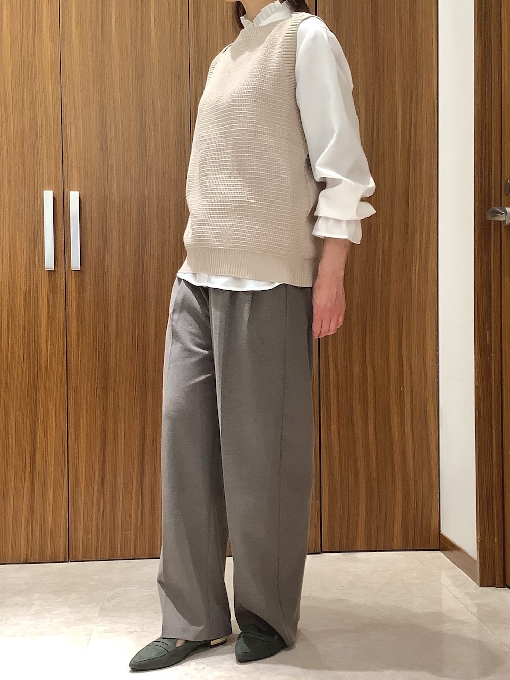 ベージュ系のベストを着用したレディースの春コーディネートの3枚目の写真