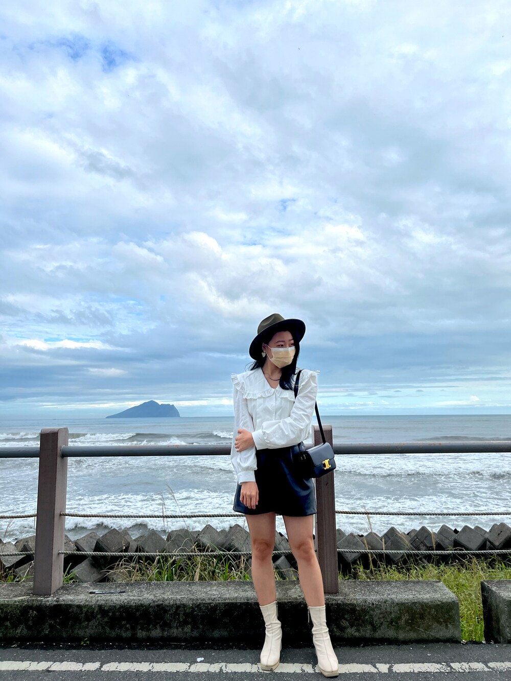 ホワイト系のトップス、ブラック系のパンツ、ブラック系のバッグを着用したレディースの夏コーディネートの2枚目の写真