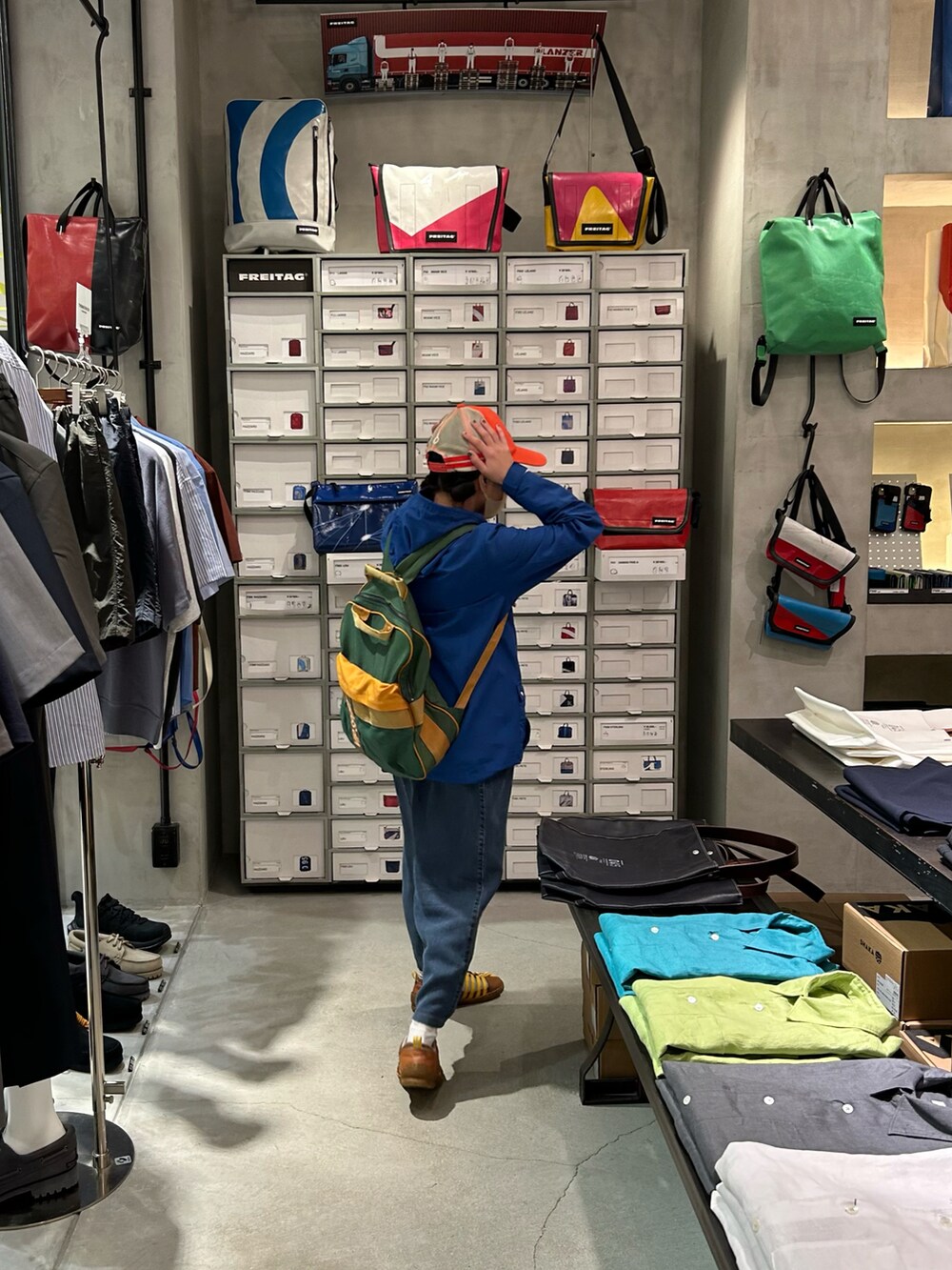 ブルー系のナイロンジャケットを着用したレディースの夏コーディネートの2枚目の写真