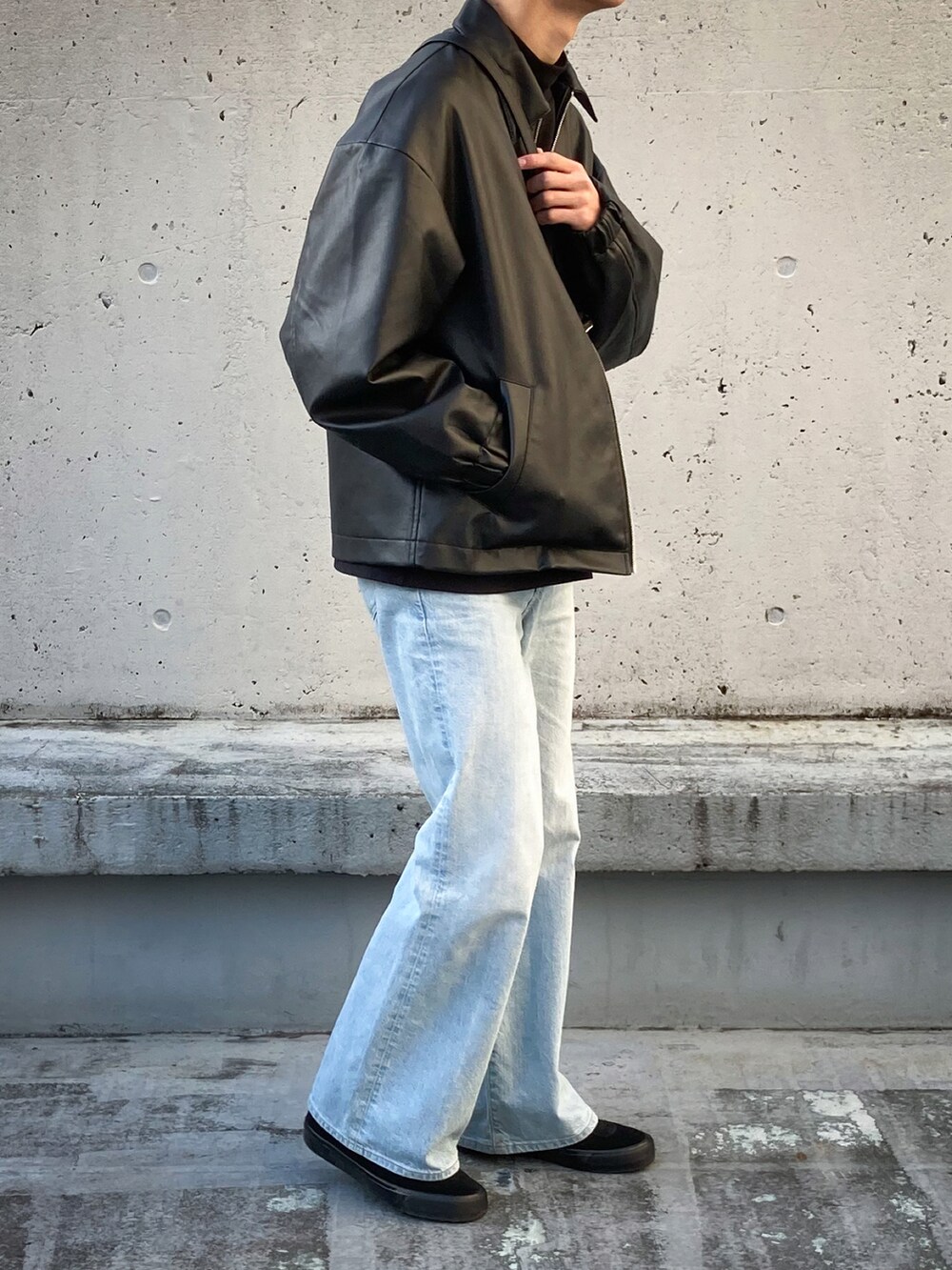 ブルー系のデニムパンツ、ブラック系のスニーカー、ブラック系のブルゾンを着用したメンズの冬コーディネートの2枚目の写真