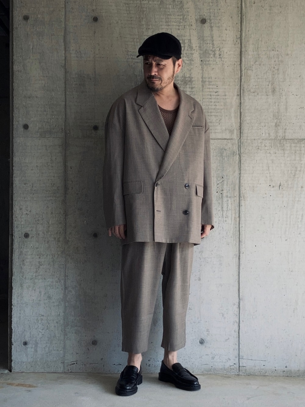 ブラウン系のタンクトップ、ブラウン系のテーラードジャケット、ブラウン系のスラックスを着用したメンズの秋コーディネートの3枚目の写真