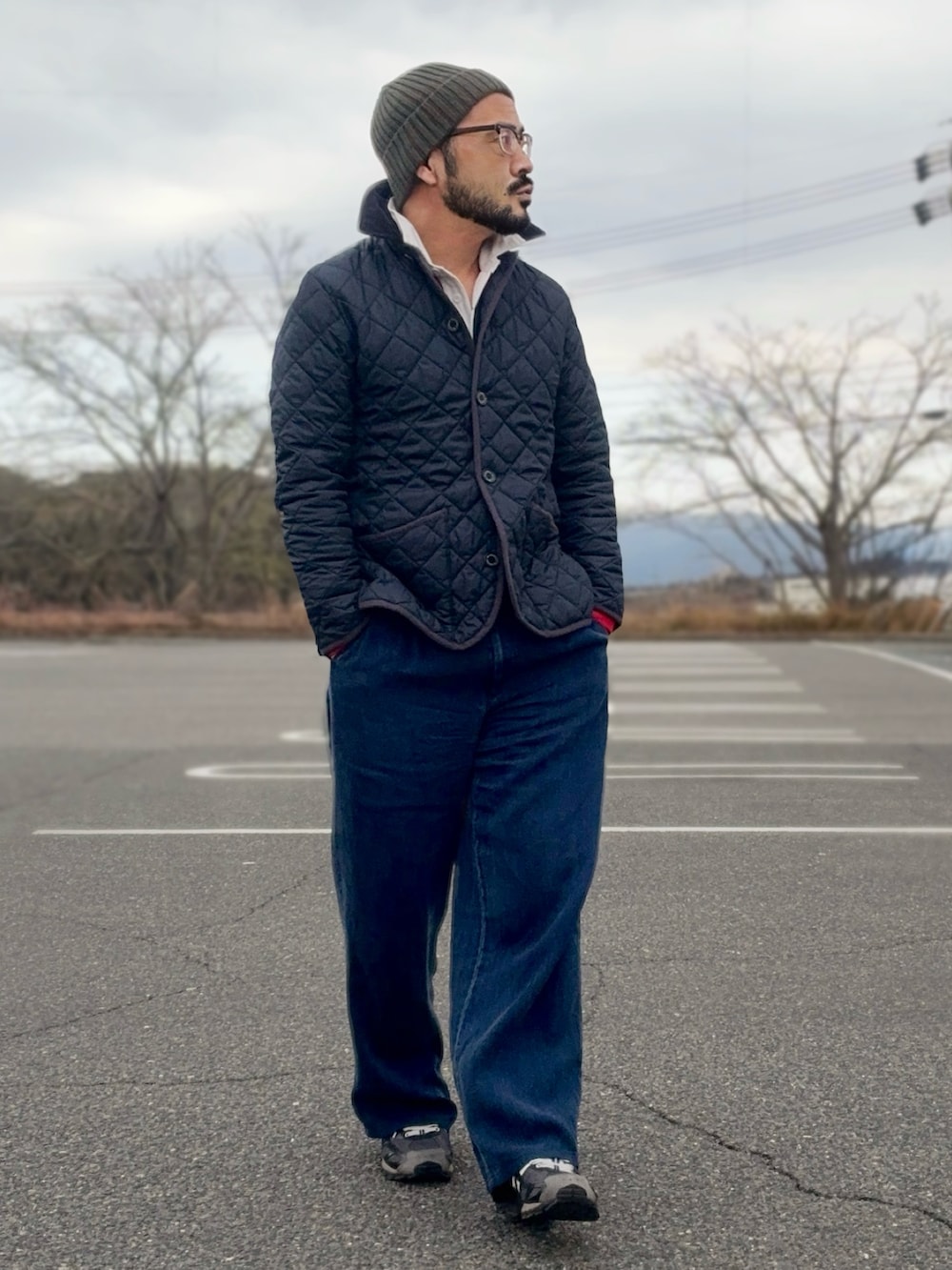 ブルー系のその他アウター、ブラック系のスニーカー、レッド系のポロシャツを着用したメンズの冬コーディネートの2枚目の写真