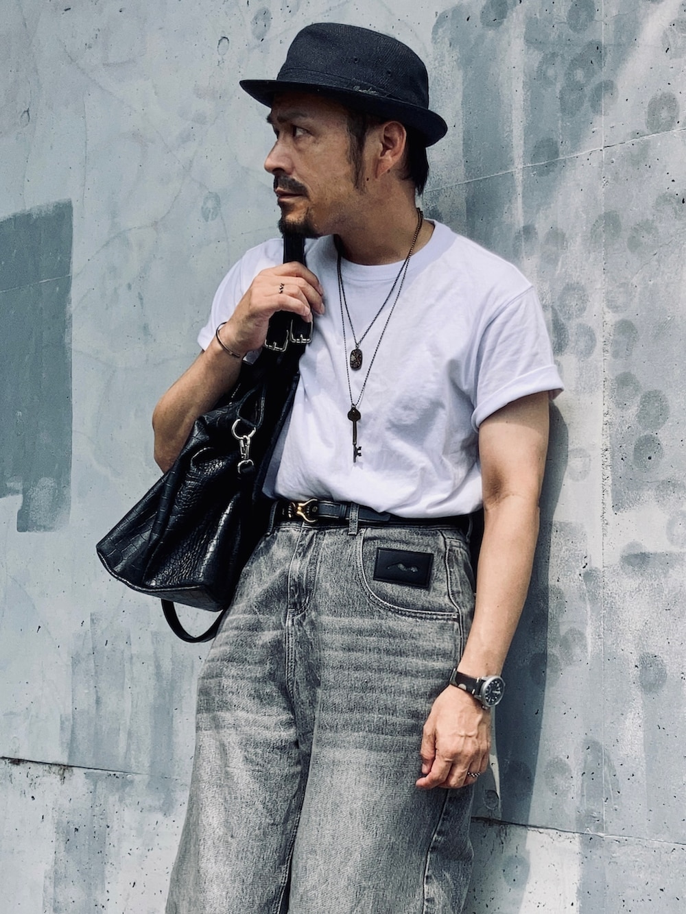 ホワイト系のTシャツ/カットソー、グレー系のデニムパンツ、ブラック系のドレスシューズを着用したメンズの秋コーディネートの4枚目の写真