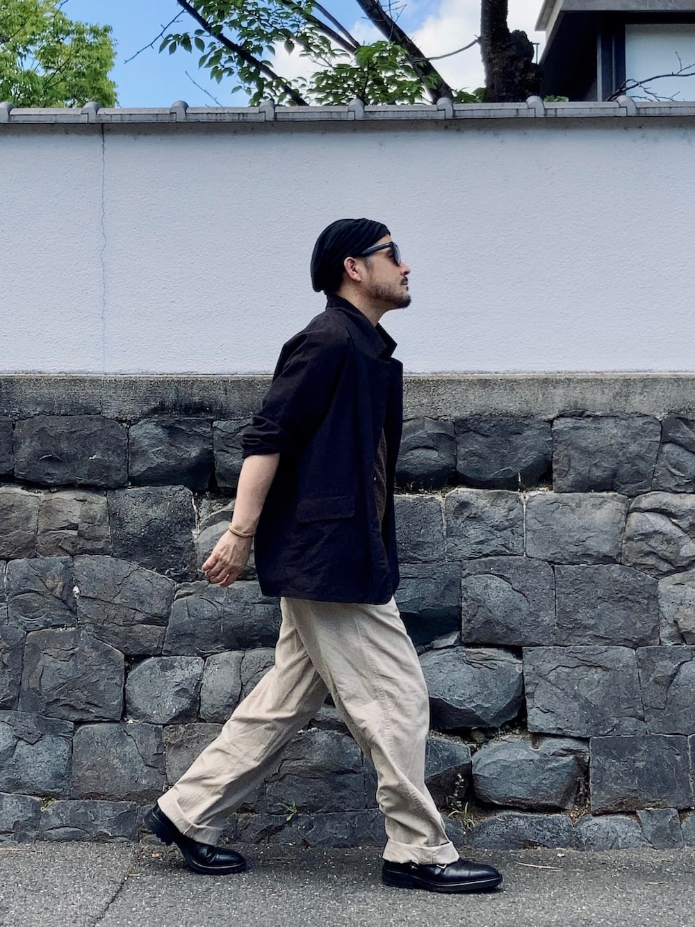 ブラック系のタンクトップ、ブラウン系のタンクトップ、ブラック系のテーラードジャケットを着用したメンズの夏コーディネートの4枚目の写真