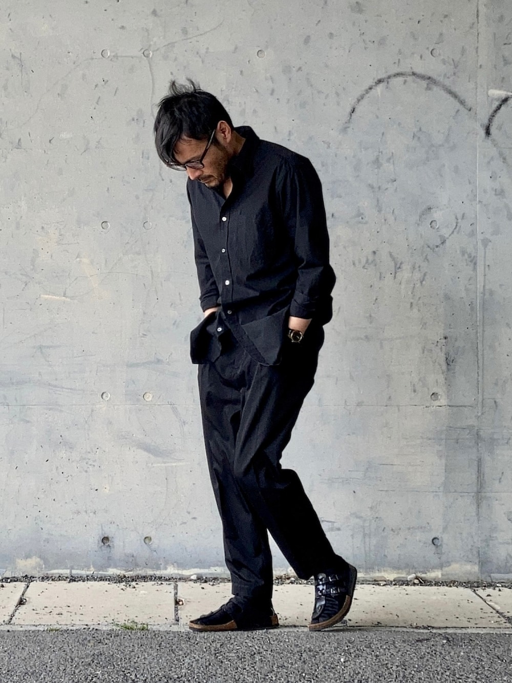 ブラック系のシャツ/ブラウス、ブラック系のスラックス、ブラック系のサンダルを着用したメンズの春コーディネートの3枚目の写真