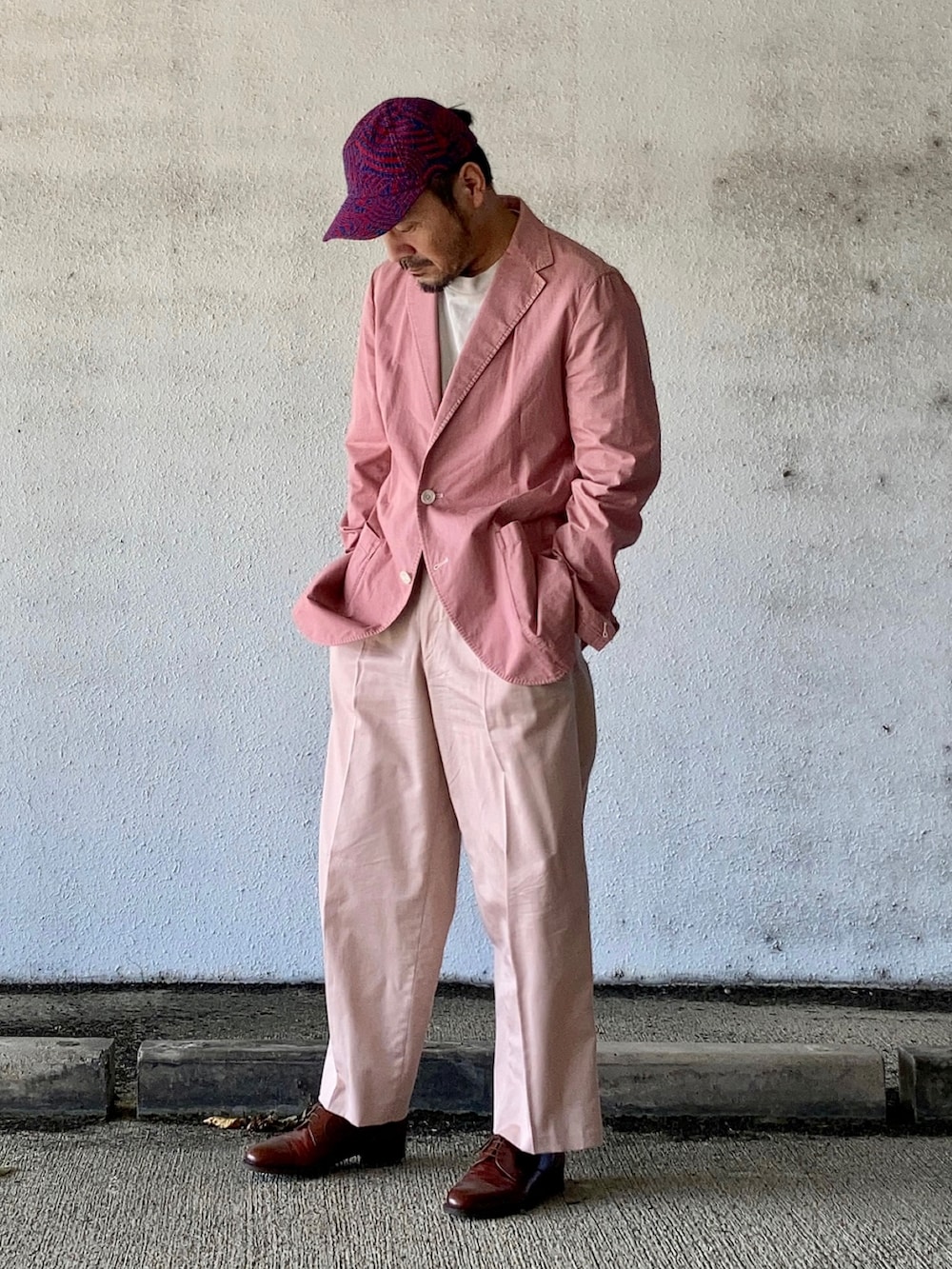 グレー系のTシャツ/カットソー、ピンク系のテーラードジャケット、ピンク系のスラックスを着用したメンズの秋コーディネートの2枚目の写真