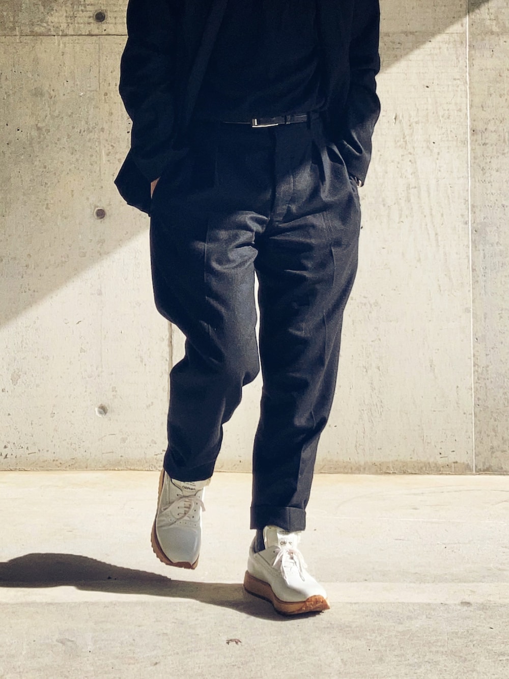 ブラック系のニット/セーター、ブラック系のスラックス、ブラック系のテーラードジャケットを着用したメンズの冬コーディネートの3枚目の写真