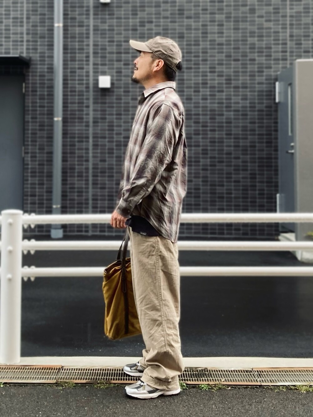 ベージュ系のシャツ/ブラウス、ベージュ系のスラックス、ブラック系のスニーカーを着用したメンズの春コーディネートの2枚目の写真