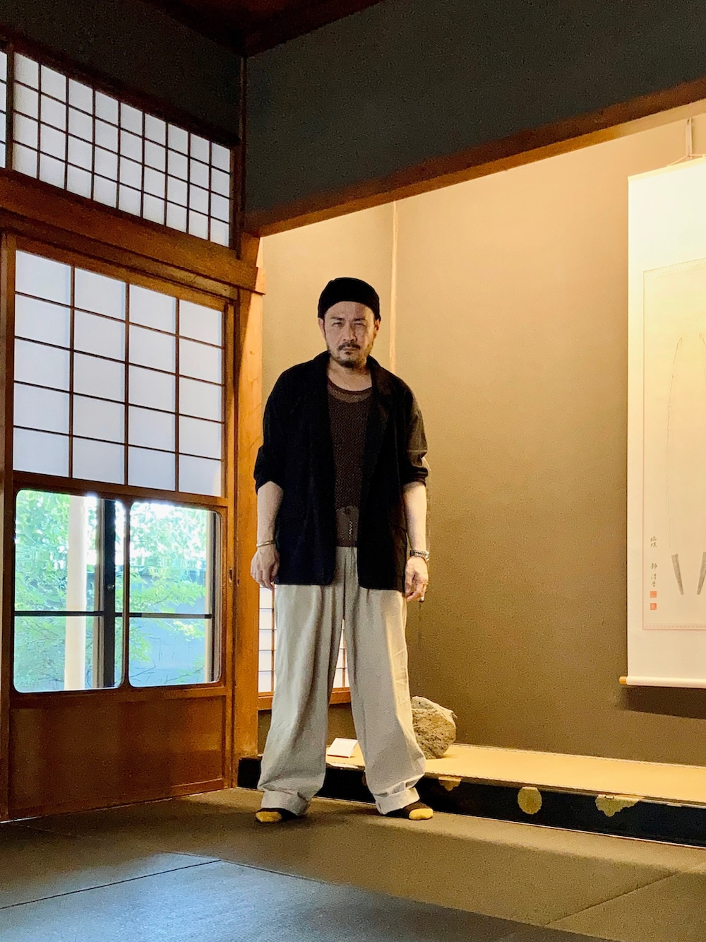 ブラック系のタンクトップ、ブラウン系のタンクトップ、ブラック系のテーラードジャケットを着用したメンズの夏コーディネートの5枚目の写真