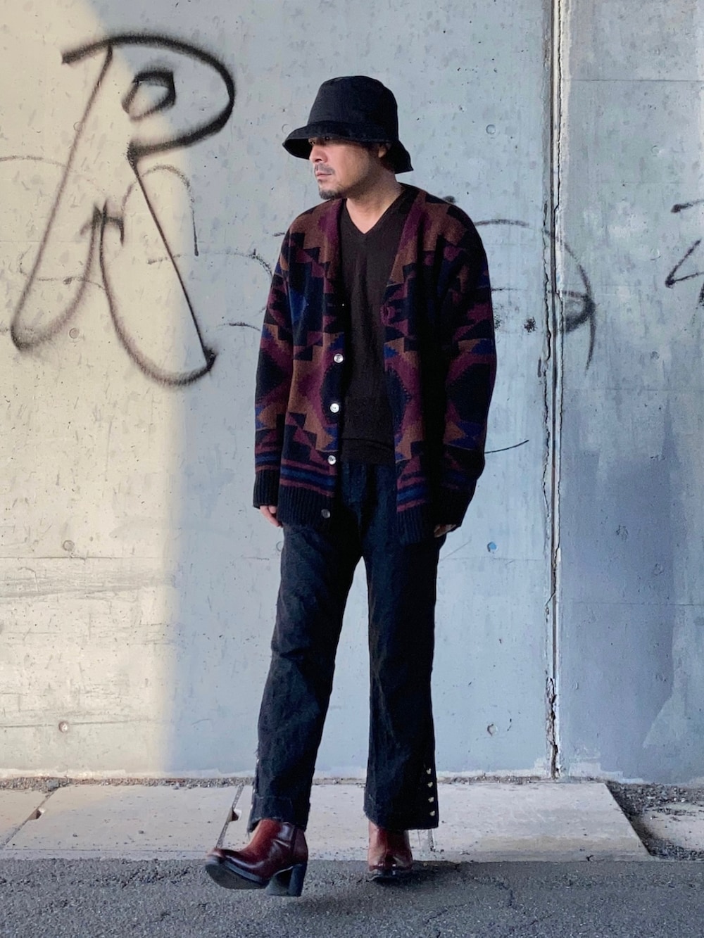 ブラック系のカーディガン/ボレロ、ブラウン系のニット/セーター、ブラック系のその他パンツを着用したメンズの秋コーディネートの2枚目の写真