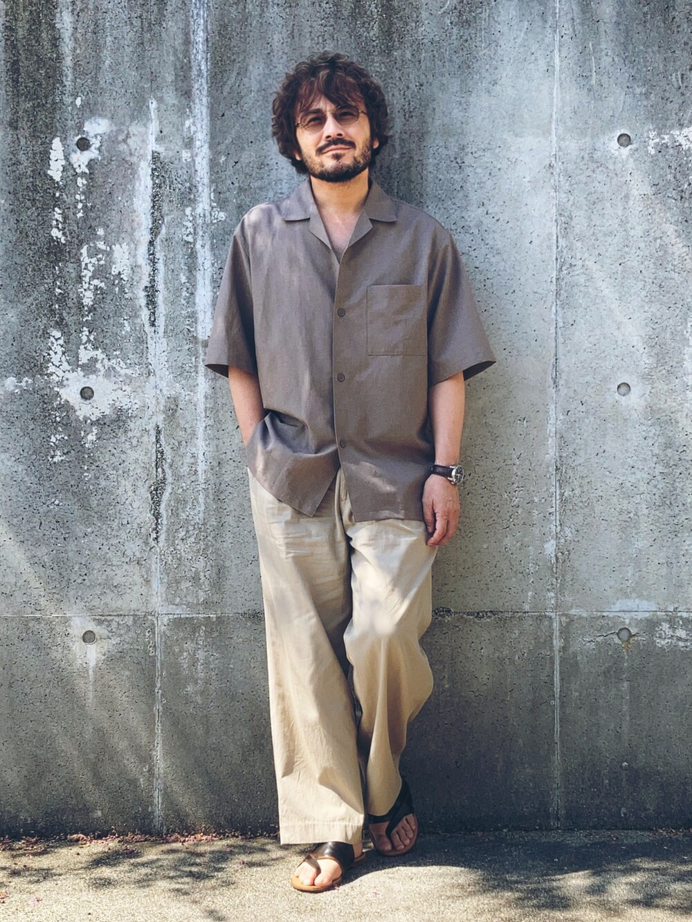 ベージュ系のスラックス、ブラウン系のシャツ/ブラウス、ブラウン系のサンダルを着用したメンズの夏コーディネートの2枚目の写真