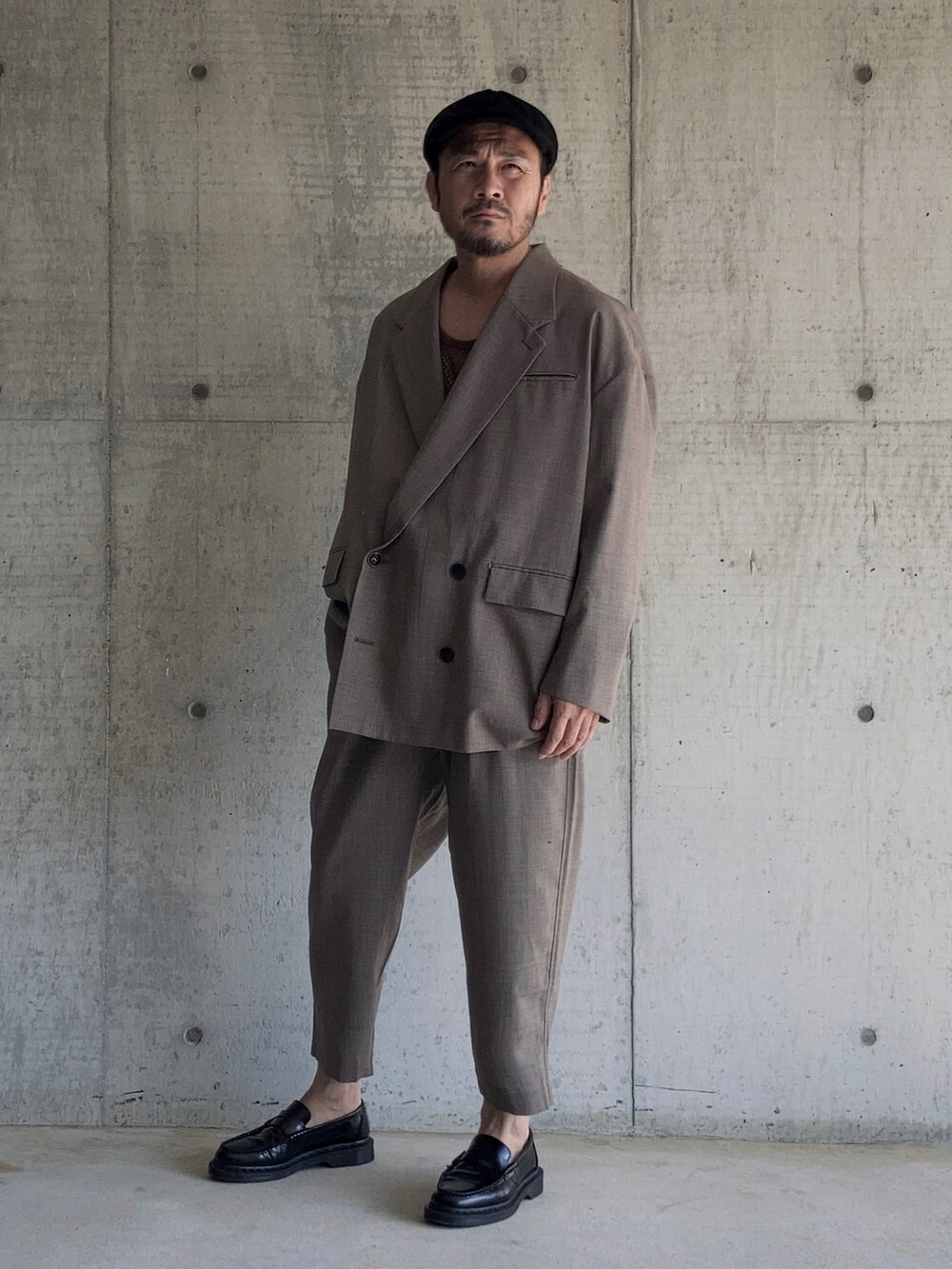 ブラウン系のタンクトップ、ブラウン系のテーラードジャケット、ブラウン系のスラックスを着用したメンズの秋コーディネートの5枚目の写真