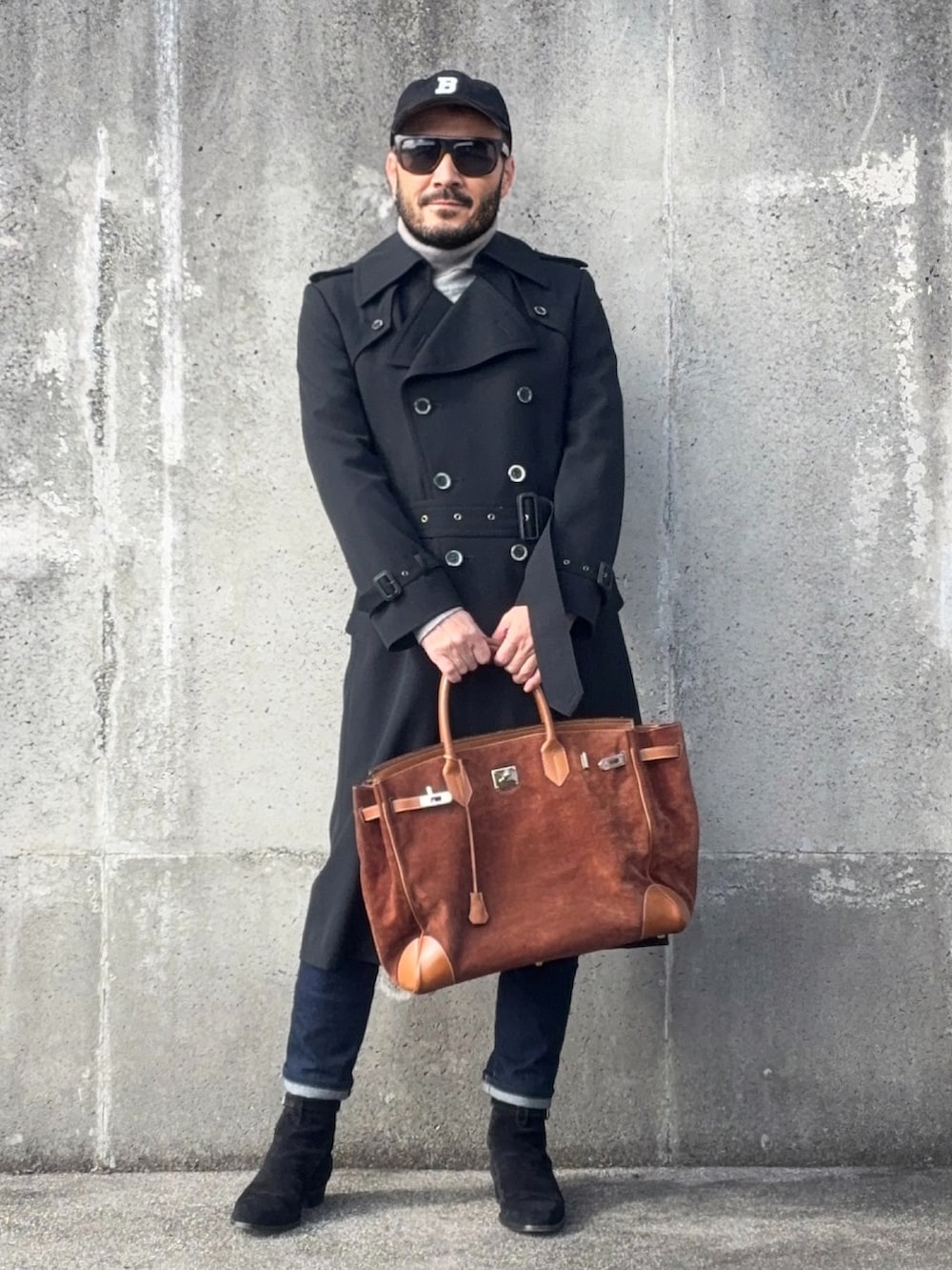 グレー系のニット/セーター、ブラック系のブーツ、ブラック系のトレンチコートを着用したメンズの冬コーディネートの3枚目の写真