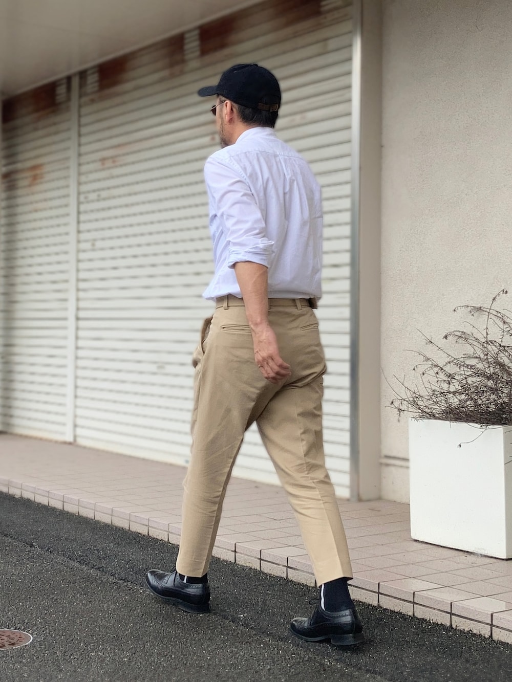 ホワイト系のシャツ/ブラウス、ベージュ系のスラックス、ブラック系のドレスシューズを着用したメンズの夏コーディネートの4枚目の写真