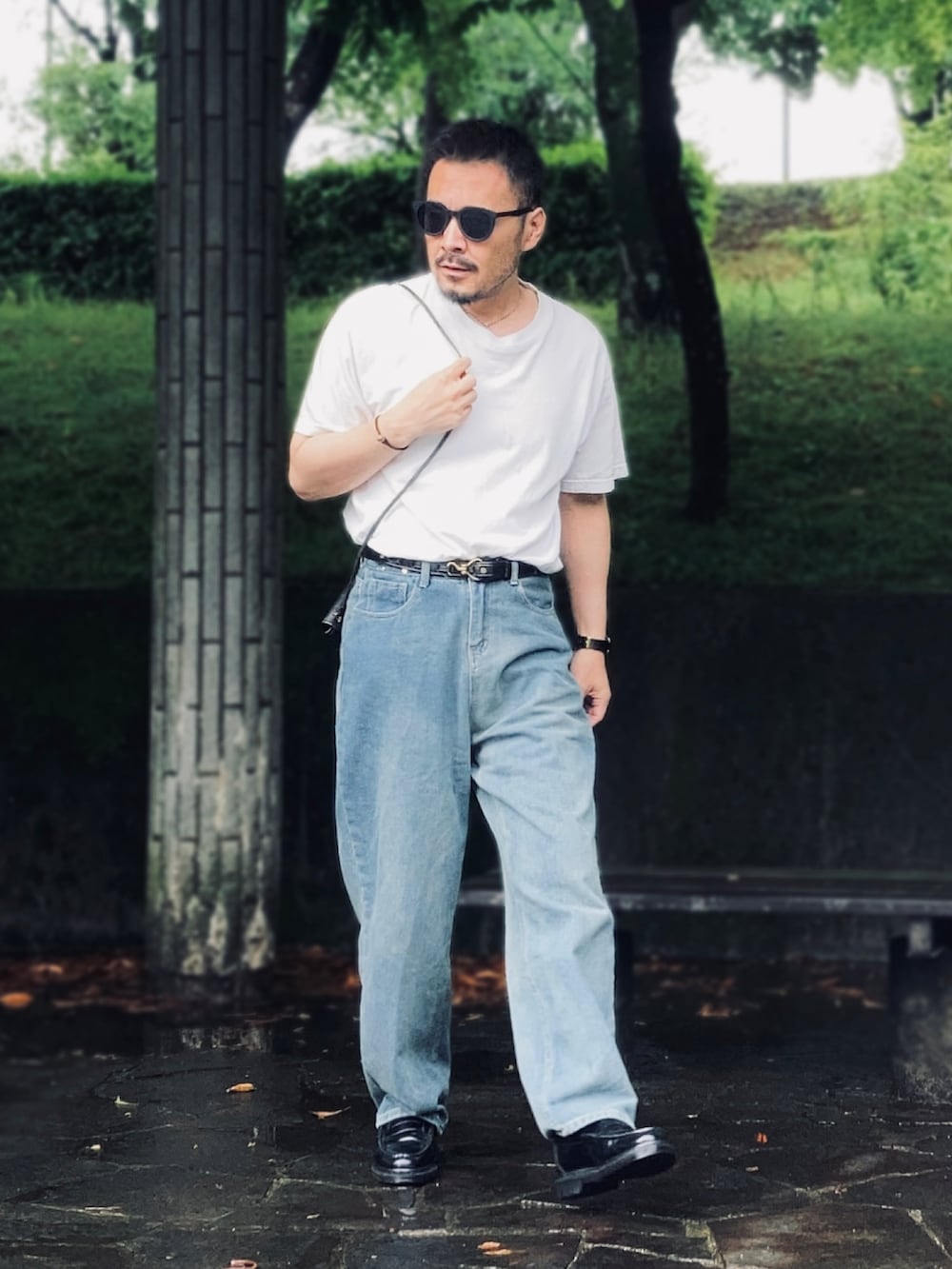 ホワイト系のTシャツ/カットソー、ブルー系のデニムパンツ、ブラック系のローファーを着用したメンズの夏コーディネートの3枚目の写真