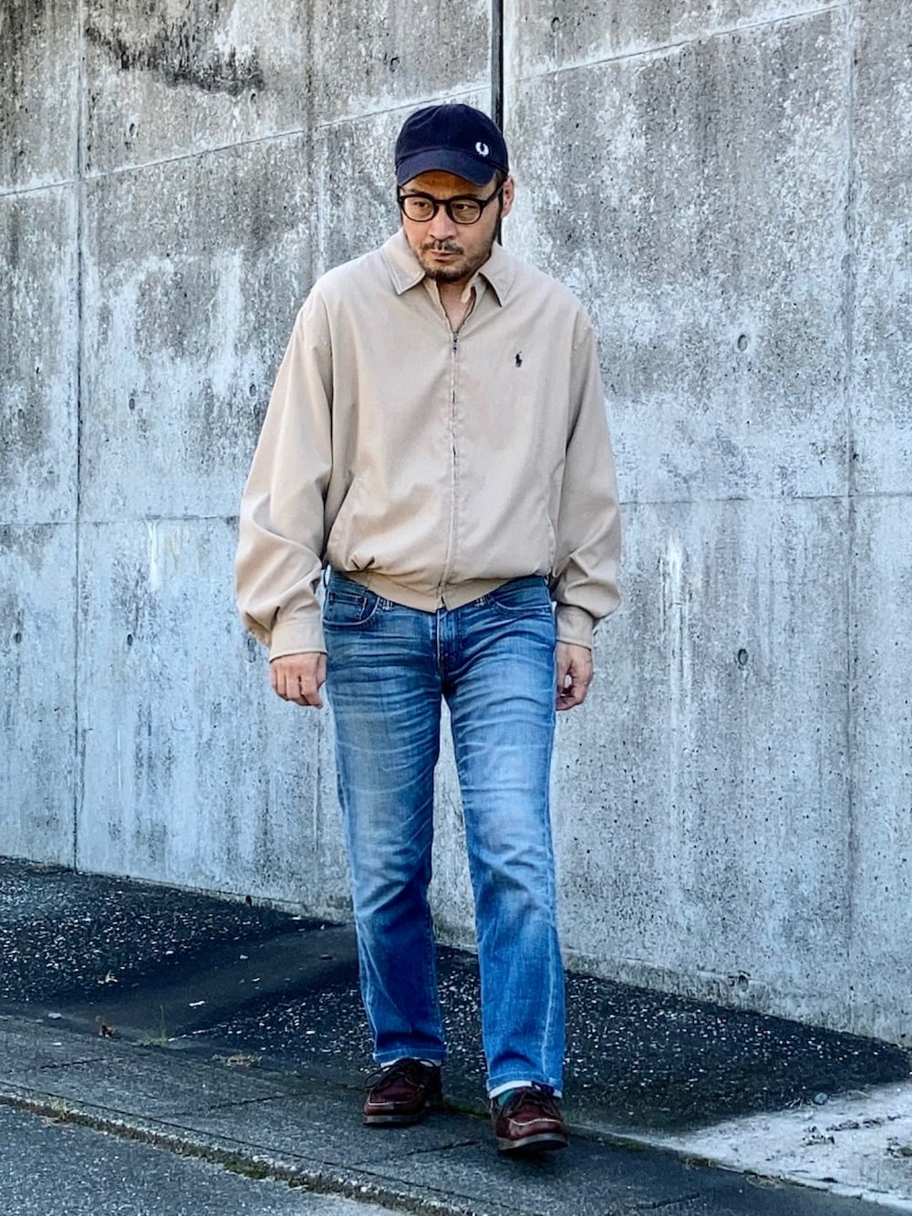 ベージュ系のブルゾン、ブルー系のデニムパンツ、ブラウン系のモカシン/デッキシューズを着用したメンズの秋コーディネートの2枚目の写真