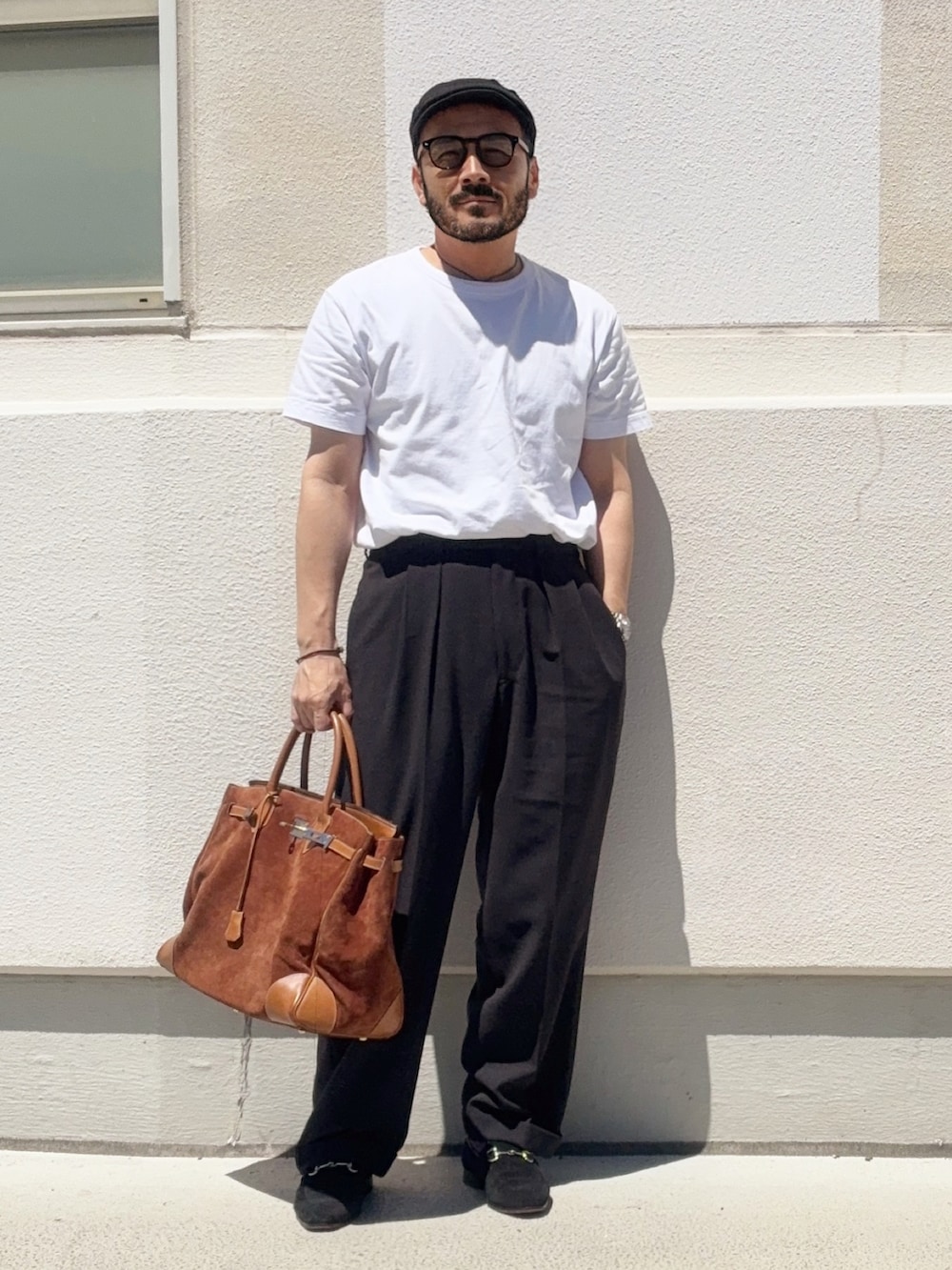 ホワイト系のTシャツ/カットソー、グレー系のスラックス、ブラウン系のトートバッグを着用したメンズの夏コーディネートの2枚目の写真