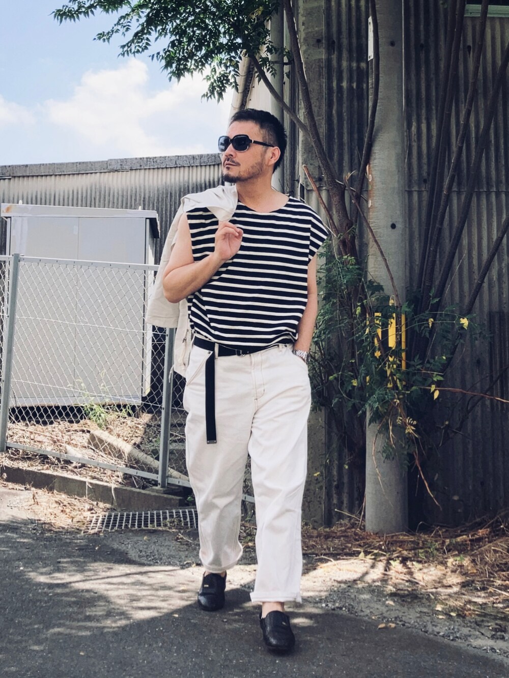 ブラック系のTシャツ/カットソー、ホワイト系のミリタリージャケット、ホワイト系のデニムパンツを着用したメンズの夏コーディネートの4枚目の写真