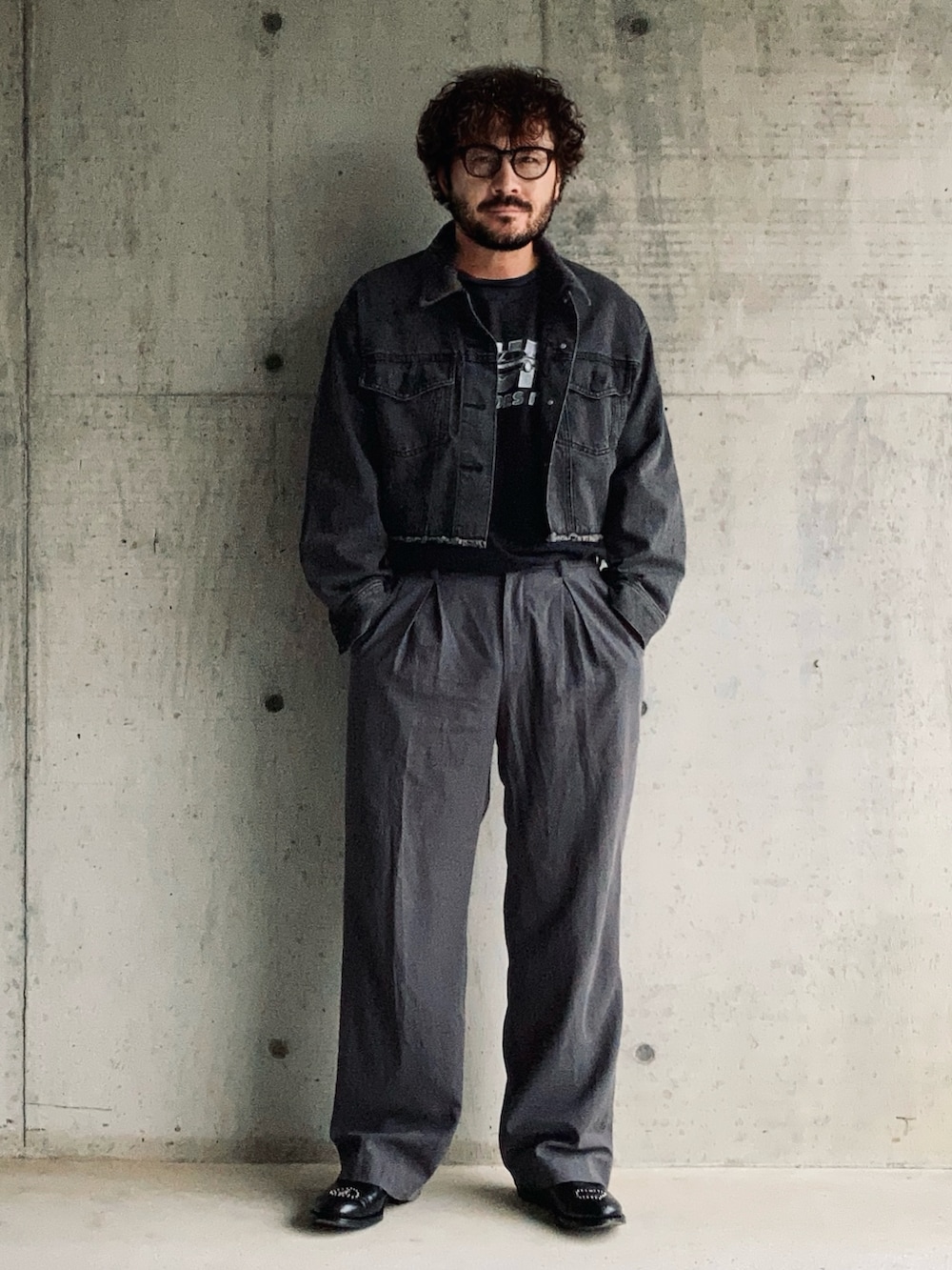 グレー系のデニムジャケット、ブラック系のTシャツ/カットソー、グレー系のスラックスを着用したメンズの秋コーディネートの2枚目の写真