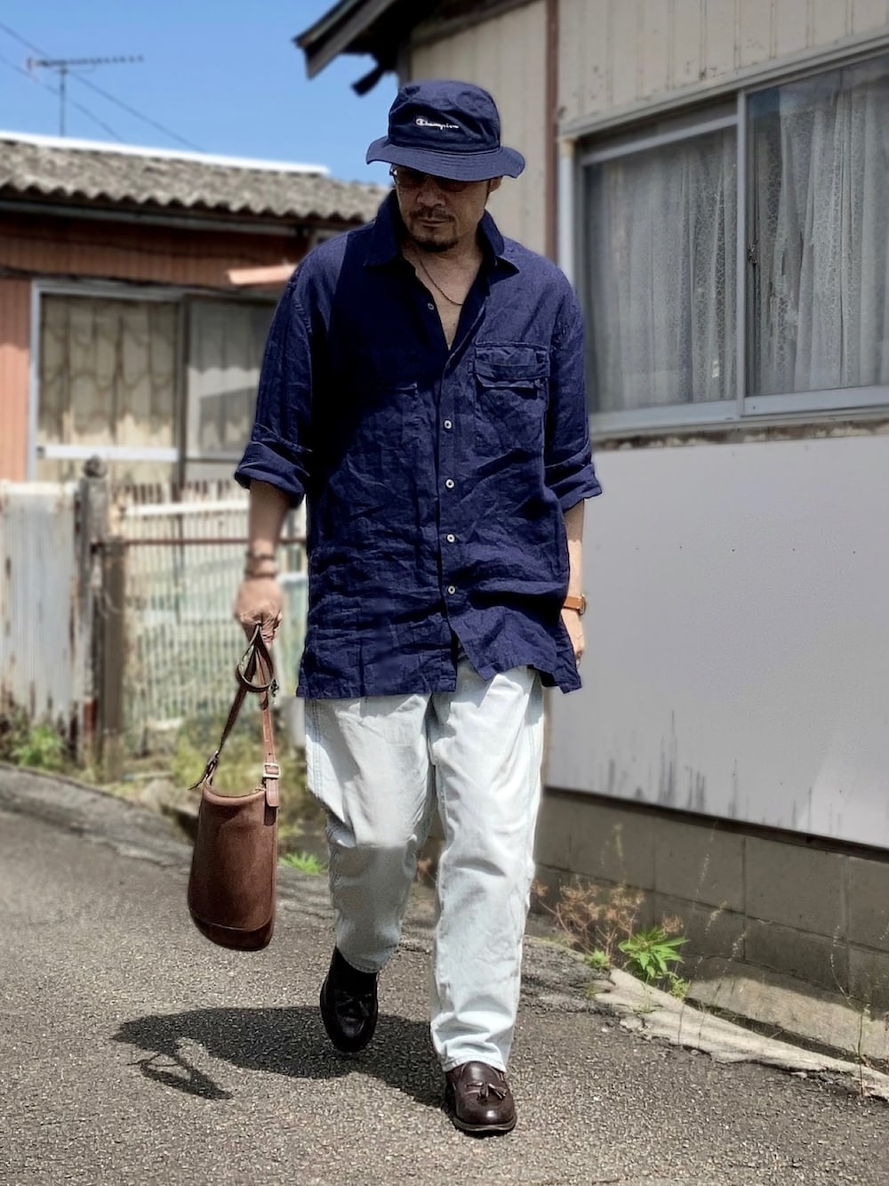 ブルー系のシャツ/ブラウス、ブルー系のデニムパンツ、ブラウン系のローファーを着用したメンズの夏コーディネートの2枚目の写真