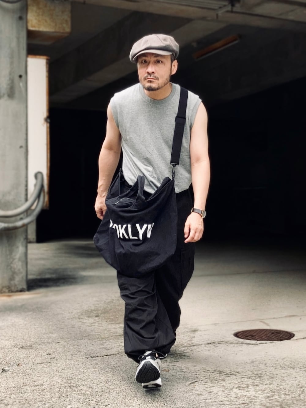 グレー系のTシャツ/カットソー、ブラック系のカーゴパンツ、ブラック系のスニーカーを着用したメンズの夏コーディネートの2枚目の写真