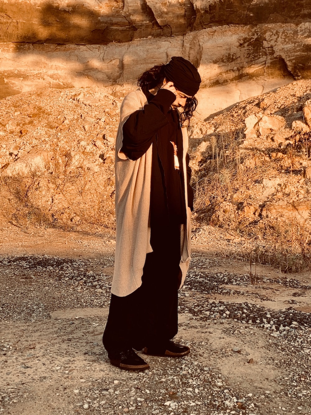 ブラック系のTシャツ/カットソー、ベージュ系のカーディガン/ボレロ、ブラック系のサンダルを着用したメンズの秋コーディネートの2枚目の写真